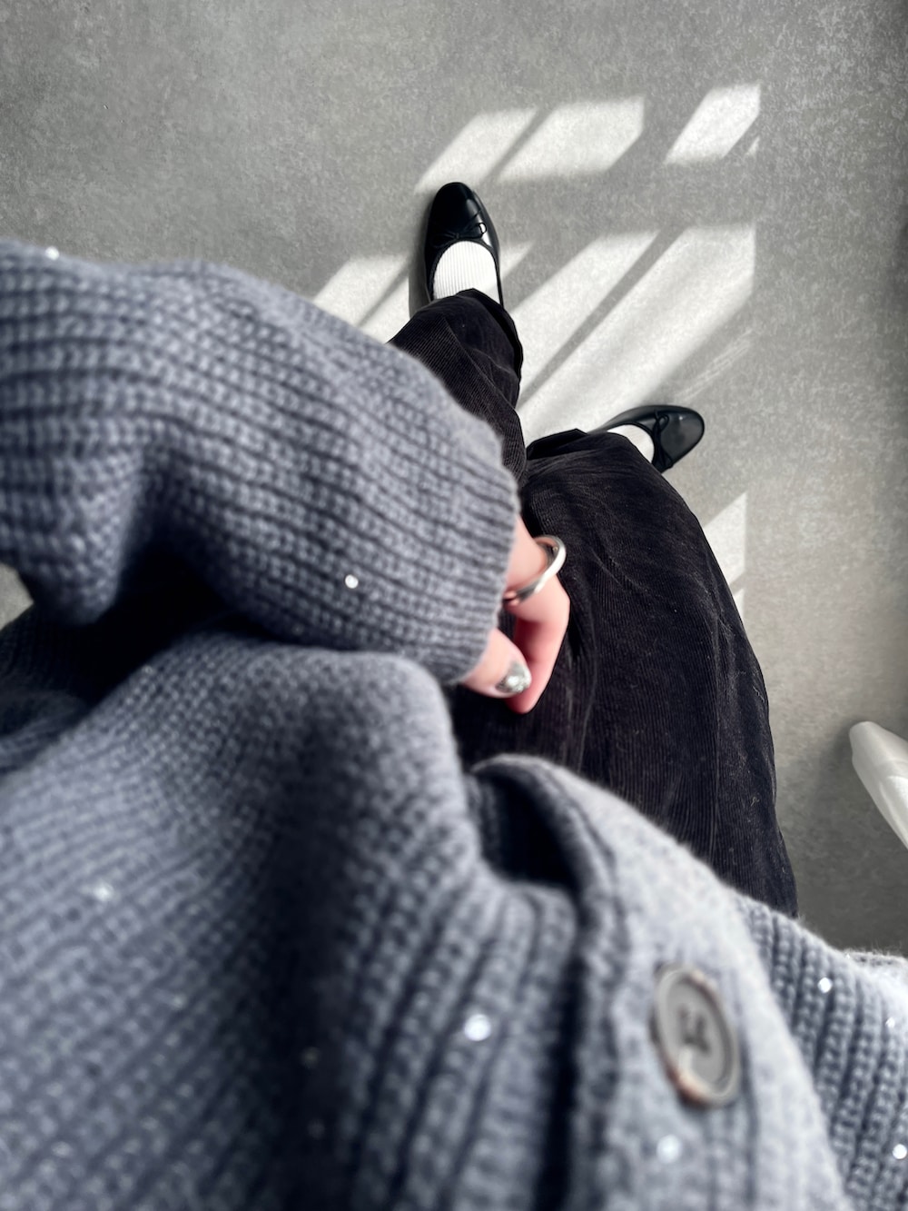 グレー系のカーディガン/ボレロ、ホワイト系のTシャツ/カットソー、ブラック系のショルダーバッグを着用したレディースの秋コーディネートの3枚目の写真