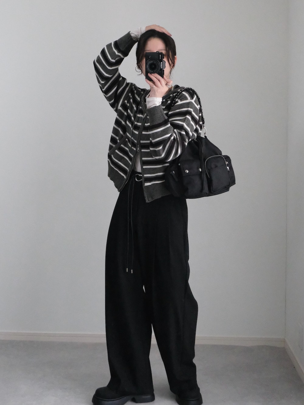 グレー系のパーカー、ブラック系のブーツ、ブラック系のTシャツ/カットソーを着用したレディースの秋コーディネートの4枚目の写真
