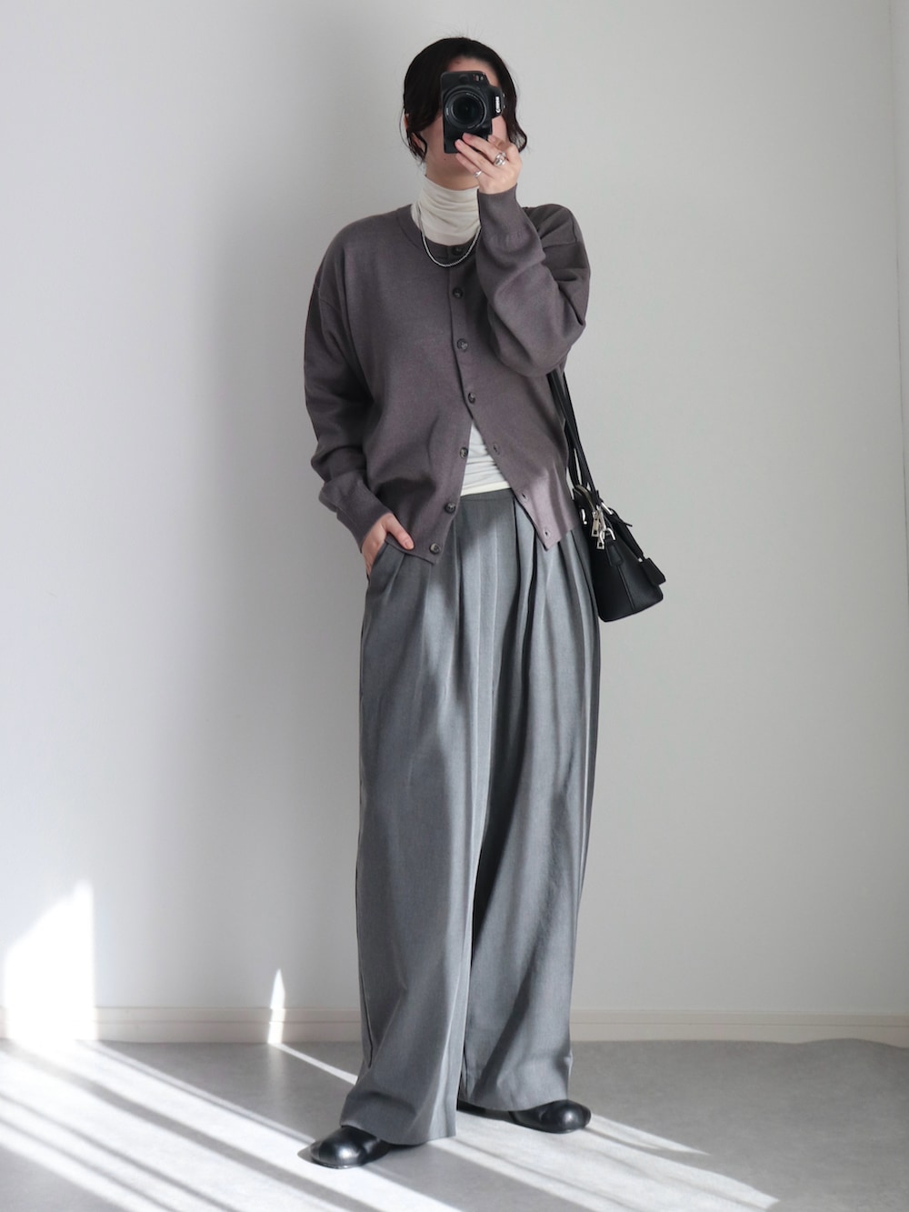 グレー系のカーディガン/ボレロ、グレー系のスラックス、ブルー系のピーコートを着用したレディースの冬コーディネートの2枚目の写真