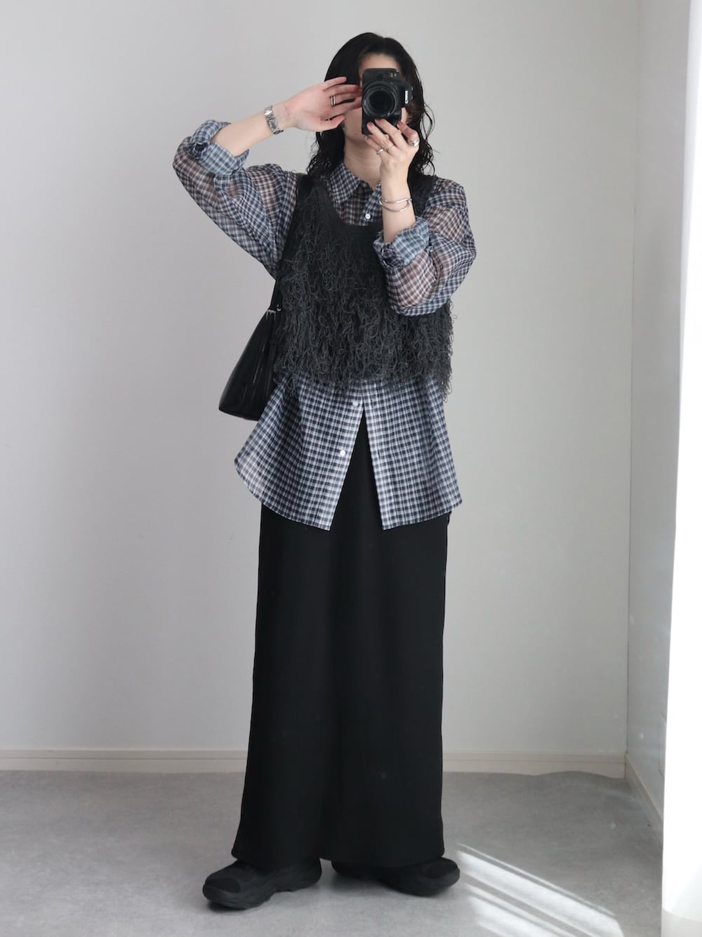 グレー系のベスト、ブラック系のシャツ/ブラウス、ブラック系のスカートを着用したレディースの秋コーディネートの2枚目の写真