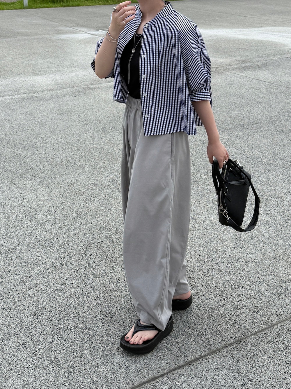 ブラック系のシャツ/ブラウス、ブラック系のショルダーバッグ、ブラック系のサンダルを着用したレディースの夏コーディネートの2枚目の写真