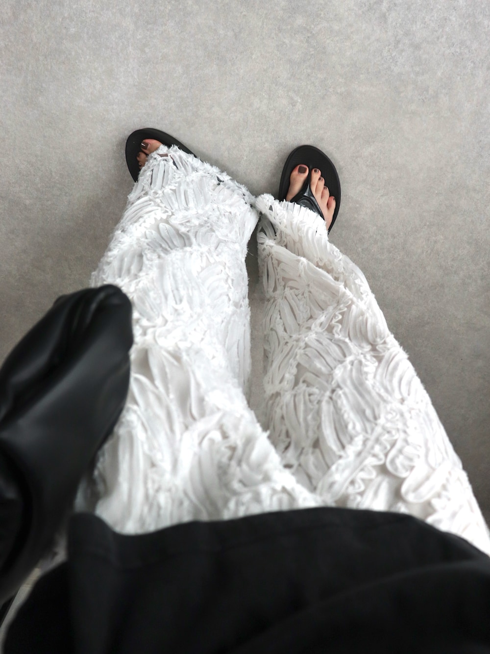 ブラック系のTシャツ/カットソー、ブラック系のサンダル、ホワイト系のその他パンツを着用したレディースの夏コーディネートの3枚目の写真