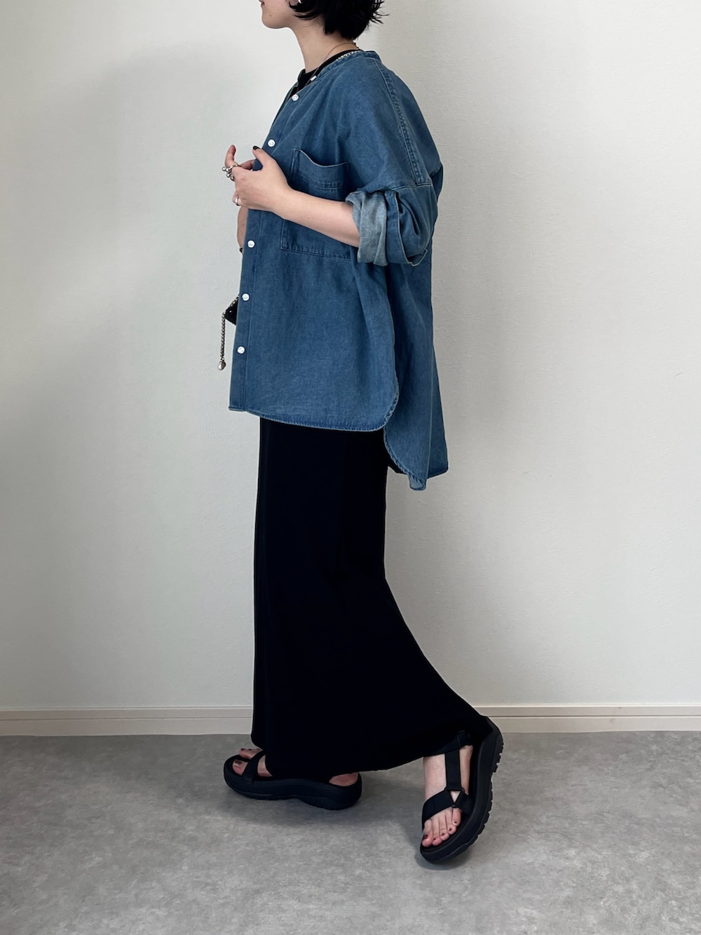 ブラック系のサンダル、ブラック系のワンピース、ブラック系のショルダーバッグを着用したレディースの秋コーディネートの2枚目の写真