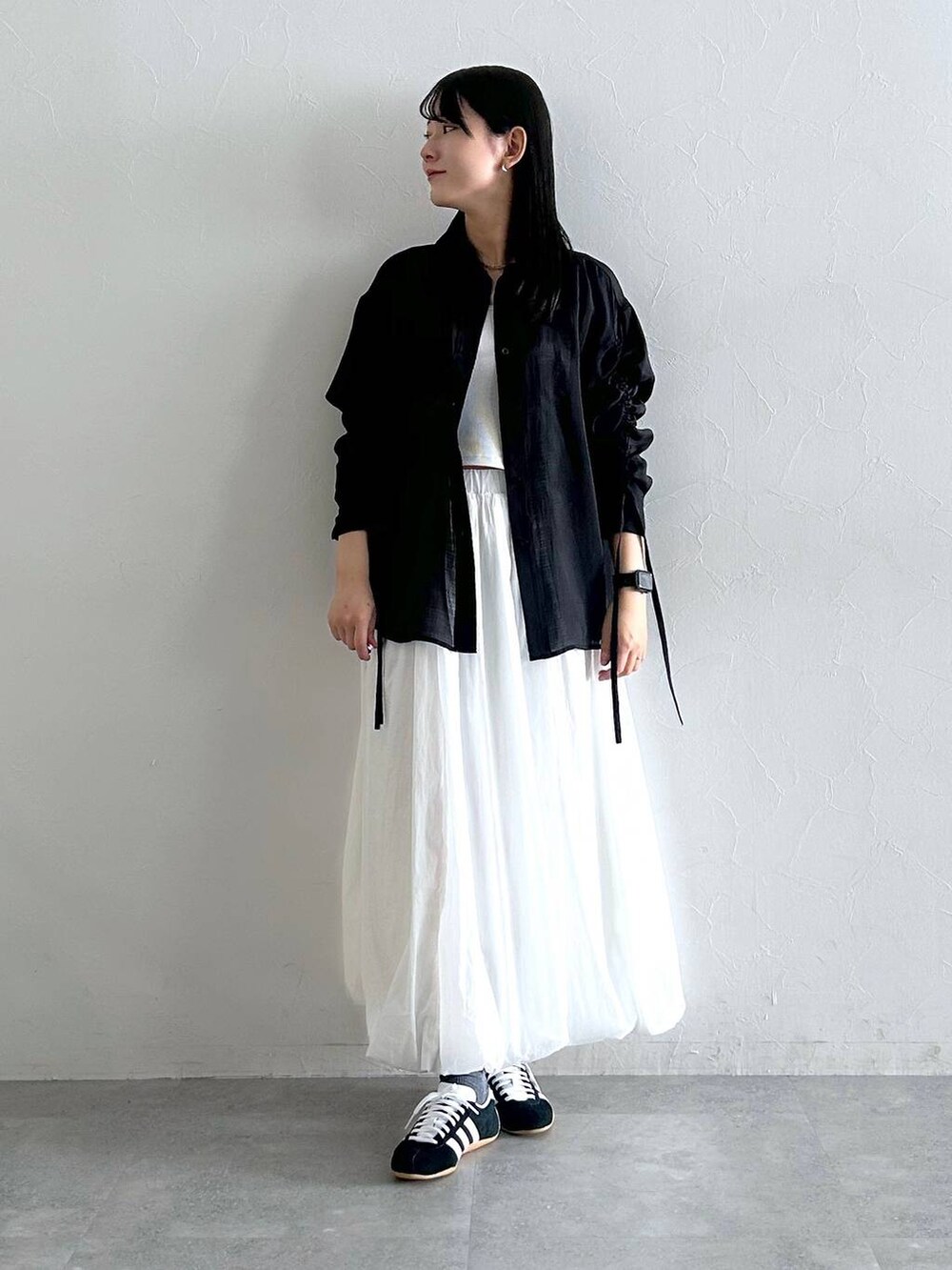 ホワイト系のスカート、ブラック系のシャツ/ブラウスを着用したレディースの夏コーディネートの2枚目の写真