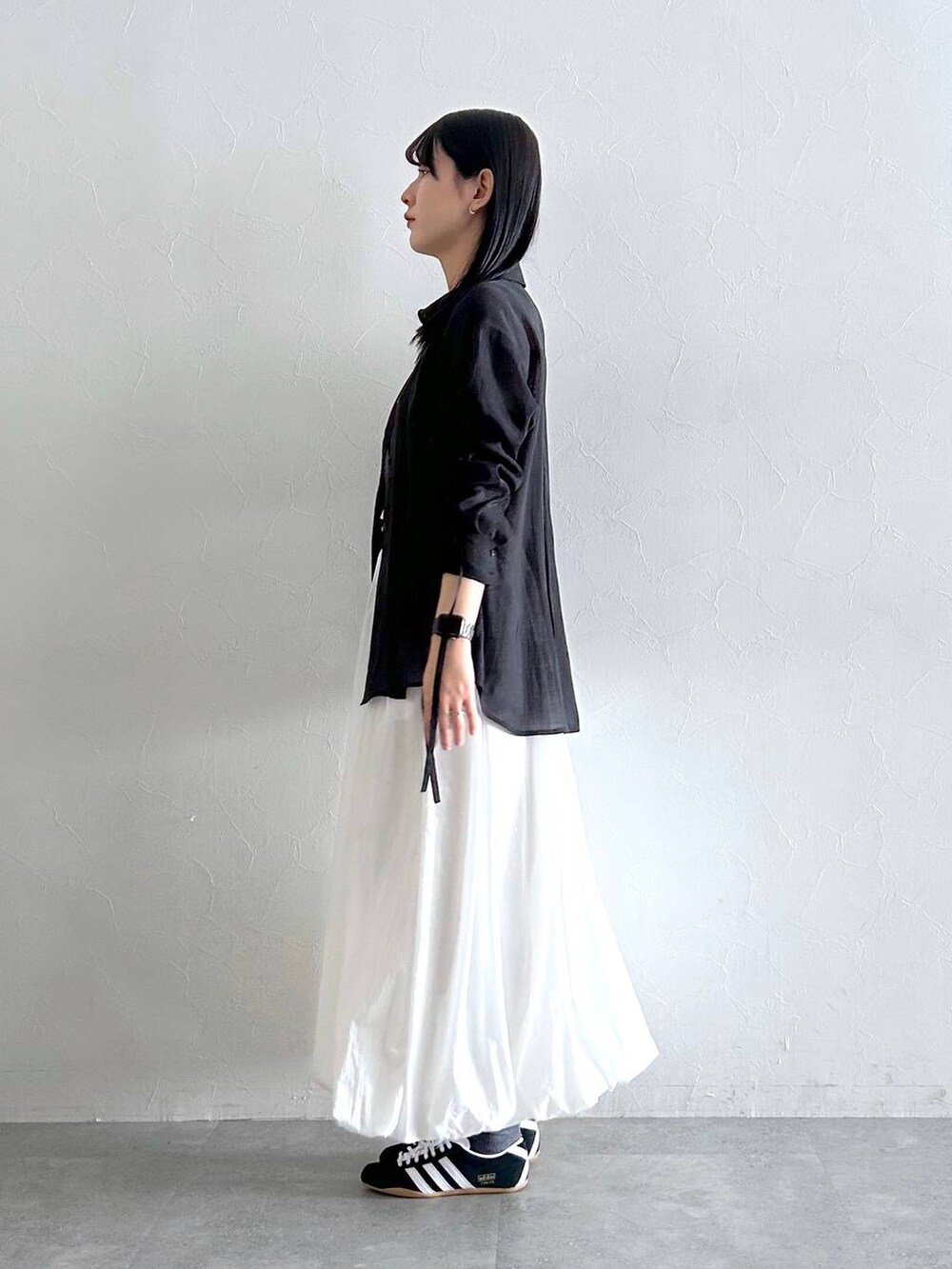 ホワイト系のスカート、ブラック系のシャツ/ブラウスを着用したレディースの夏コーディネートの4枚目の写真