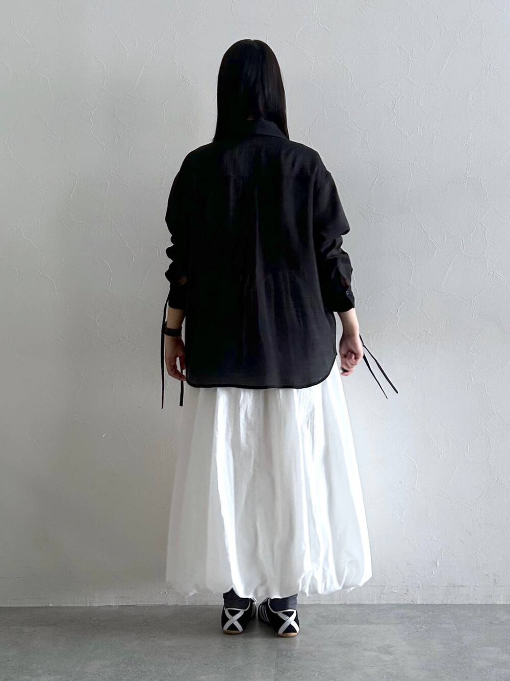 ホワイト系のスカート、ブラック系のシャツ/ブラウスを着用したレディースの夏コーディネートの5枚目の写真