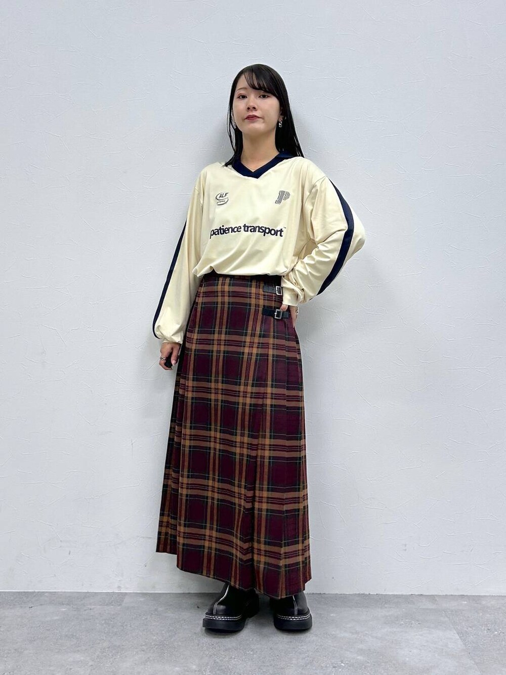 ブラック系のローファー、レッド系のスカート、ホワイト系のTシャツ/カットソーを着用したレディースの秋コーディネートの2枚目の写真