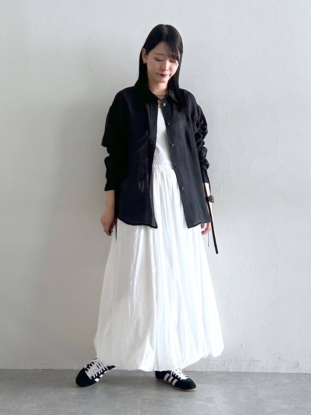 ホワイト系のスカート、ブラック系のシャツ/ブラウスを着用したレディースの夏コーディネートの3枚目の写真