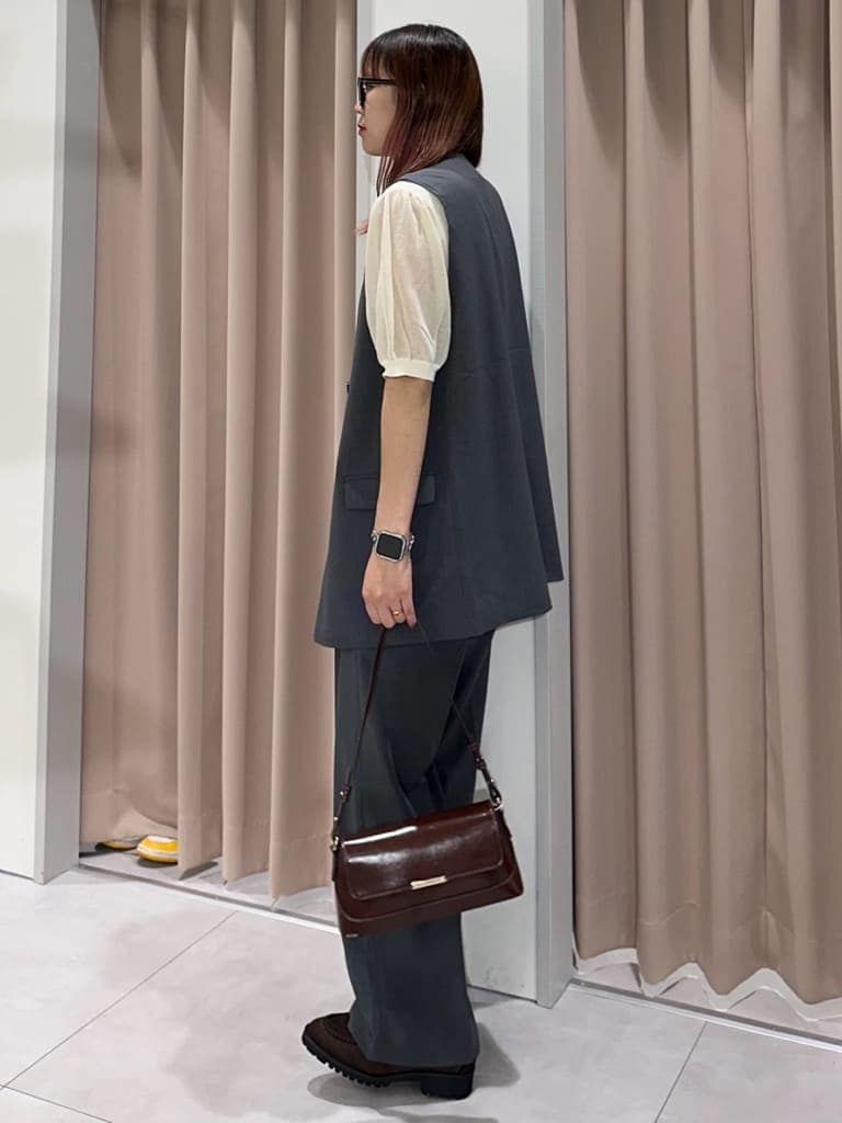グレー系のベスト、ホワイト系のニット/セーター、グレー系のその他パンツを着用したレディースの秋コーディネートの2枚目の写真