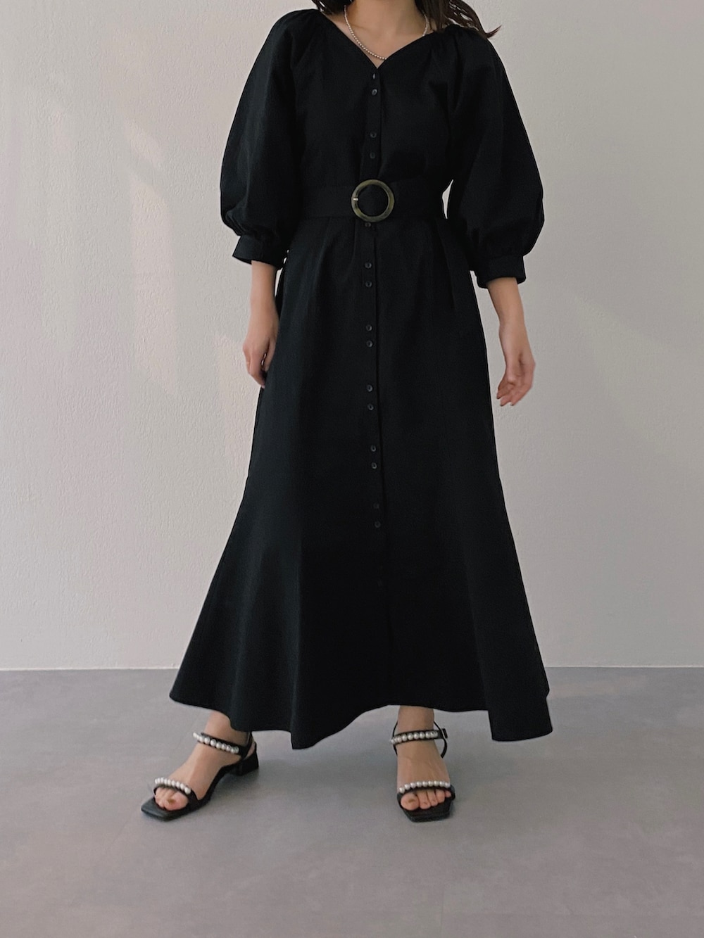 ブラック系のサンダル、ブラック系のワンピース、シルバー系のネックレスを着用したレディースの冬コーディネートの2枚目の写真