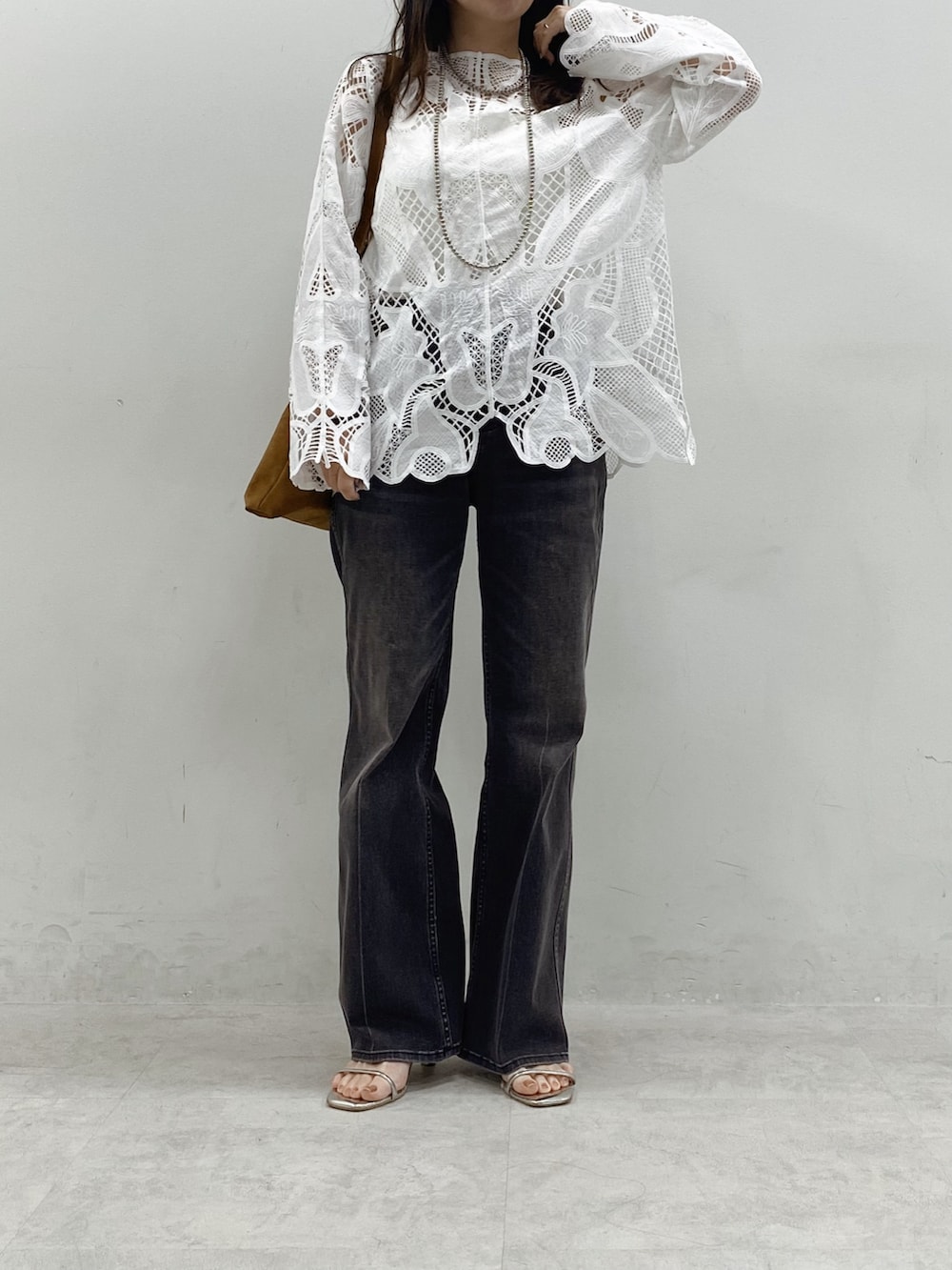 ホワイト系のシャツ/ブラウス、ブラック系のデニムパンツ、イエロー系のショルダーバッグを着用したレディースの冬コーディネートの2枚目の写真