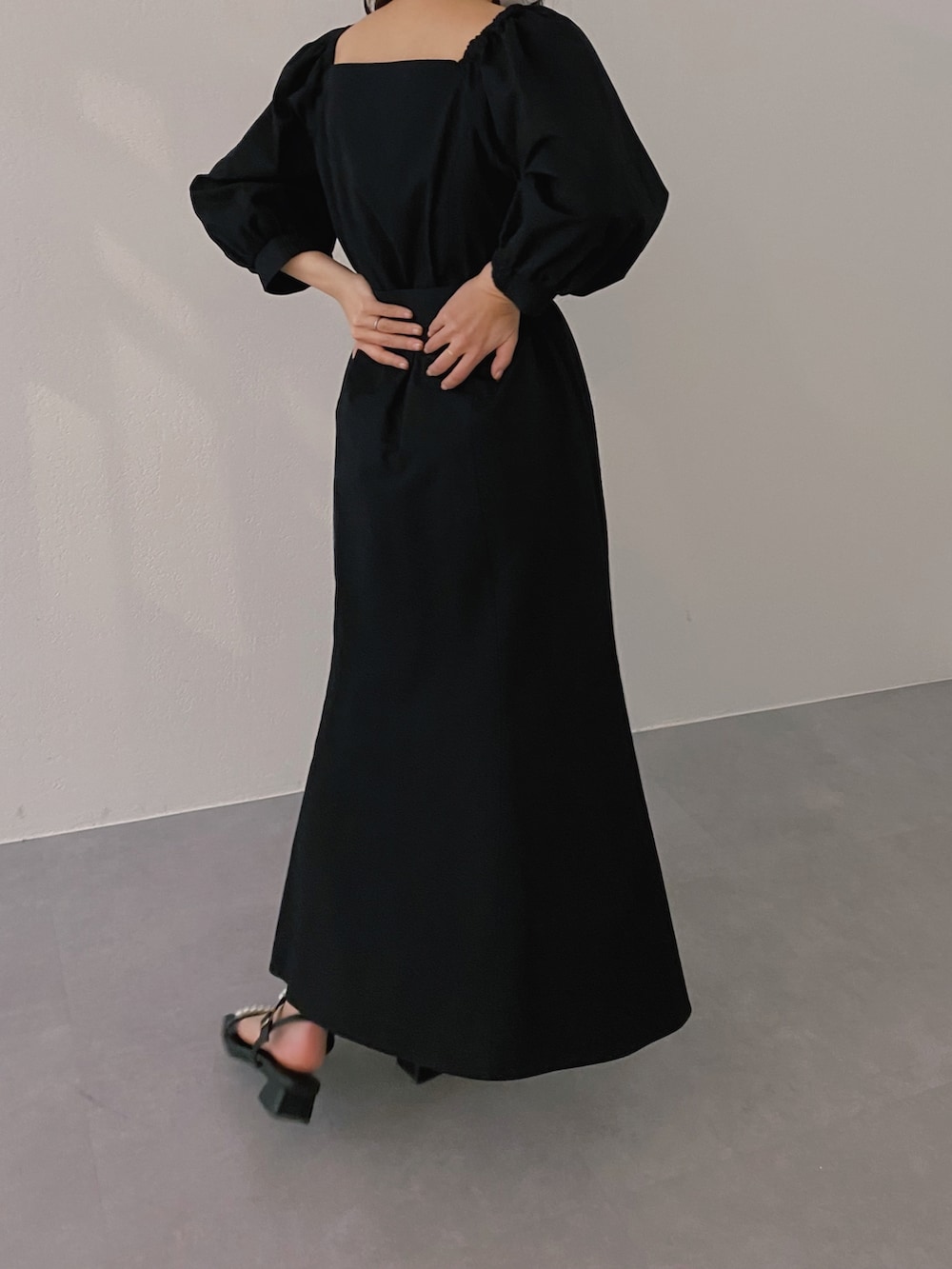 ブラック系のサンダル、ブラック系のワンピース、シルバー系のネックレスを着用したレディースの冬コーディネートの3枚目の写真