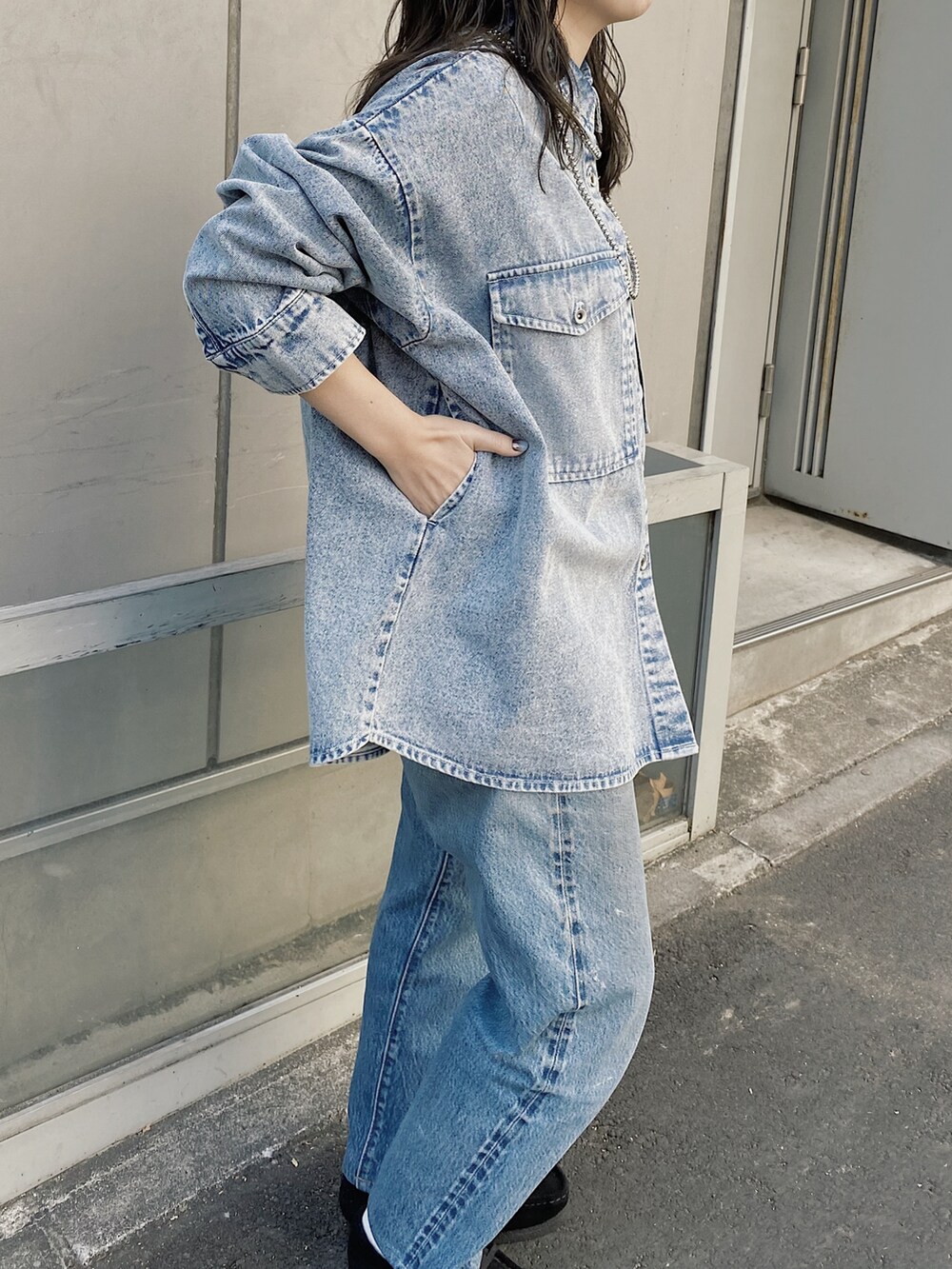 ブルー系のシャツ/ブラウス、ブルー系のデニムパンツ、ブラック系のモカシン/デッキシューズを着用したレディースの冬コーディネートの2枚目の写真