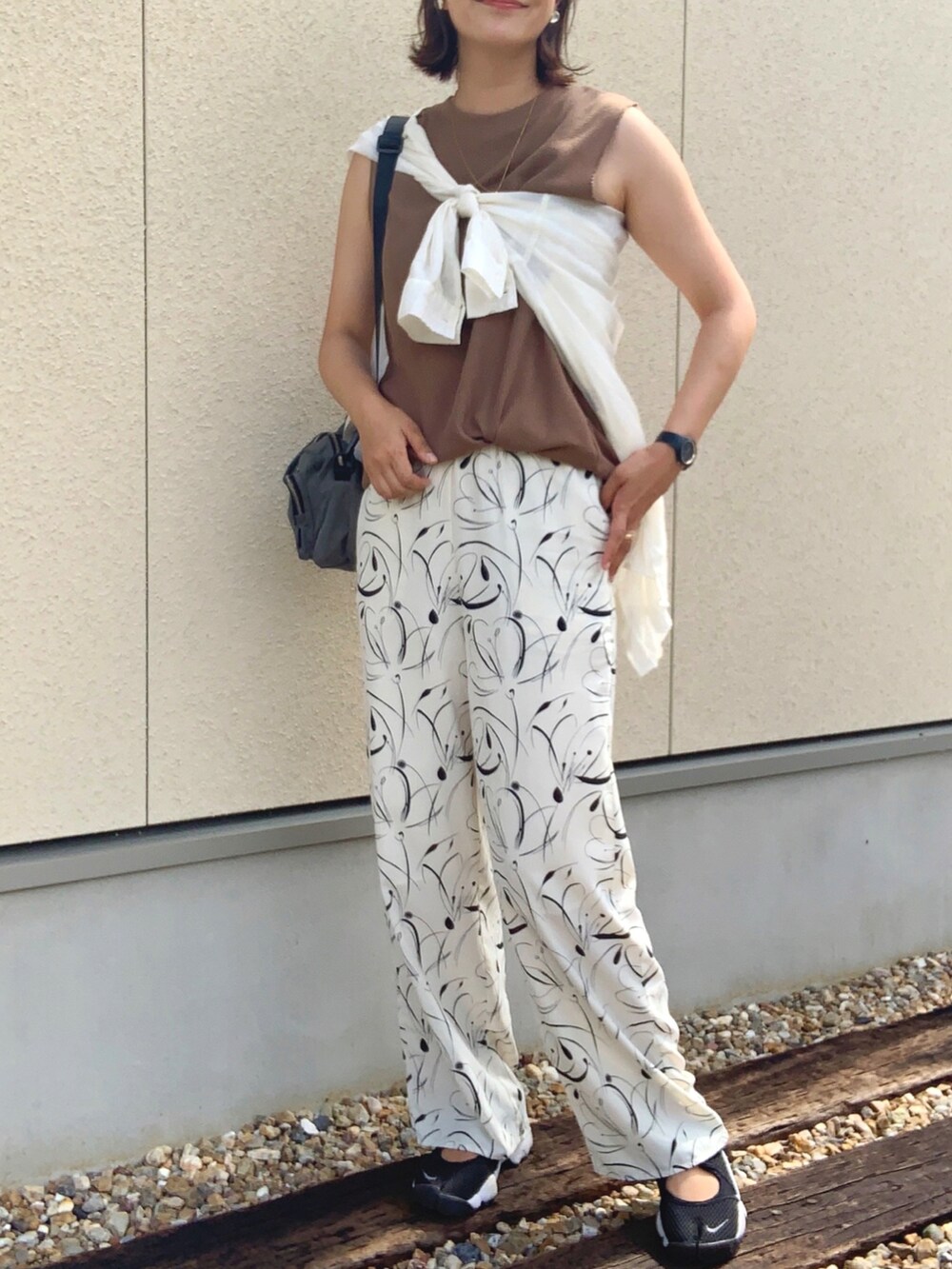 ホワイト系のその他パンツ、ベージュ系のタンクトップ、グレー系のボディバッグ/ウエストポーチを着用したレディースの夏コーディネートの3枚目の写真