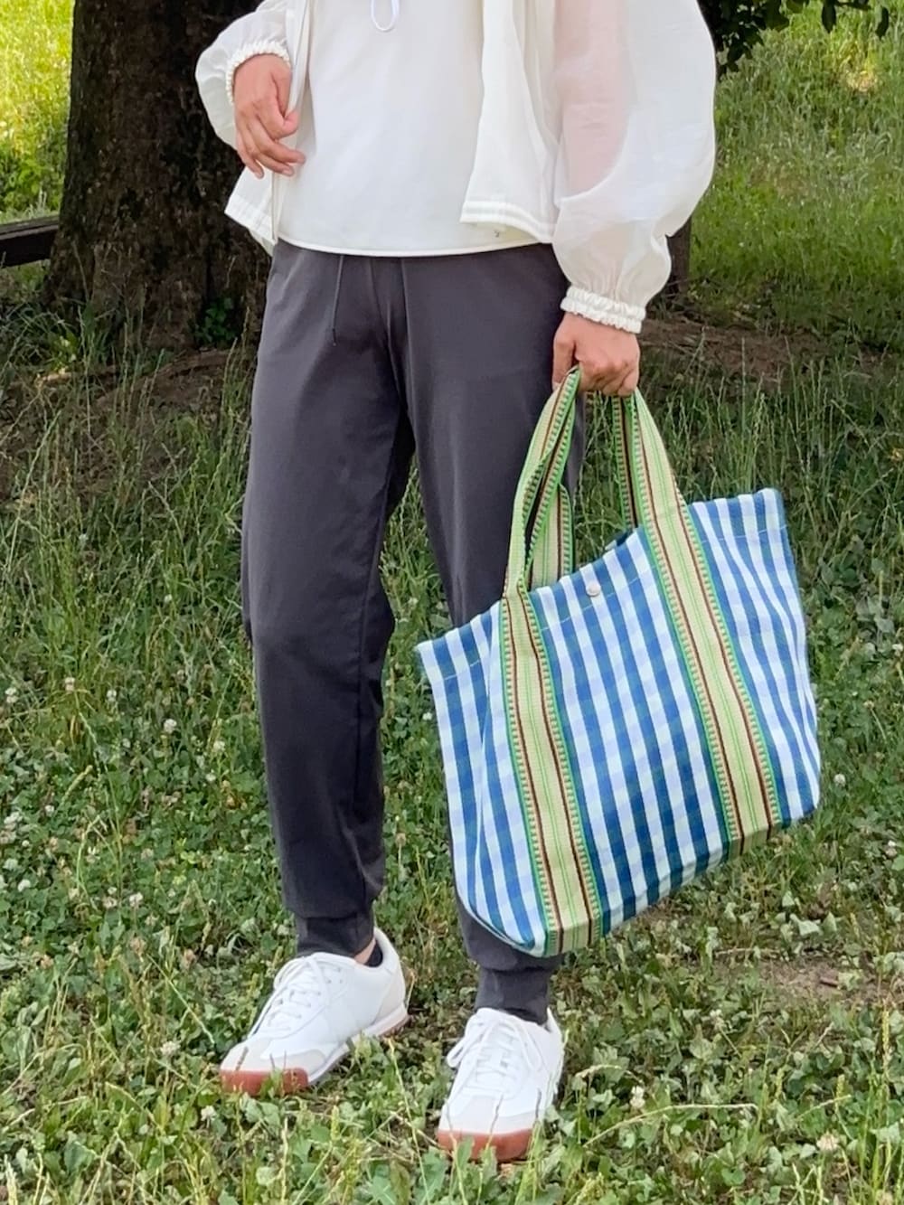 ホワイト系のブルゾン、ホワイト系のキャミソール、グレー系のその他パンツを着用したレディースの夏コーディネートの2枚目の写真