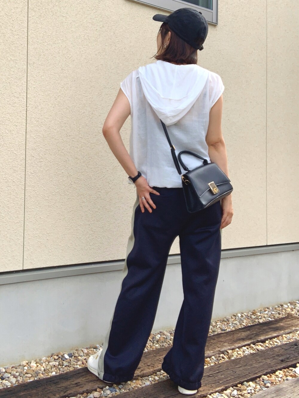 ホワイト系のベスト、ブルー系のスウェットパンツ、ホワイト系のスニーカーを着用したレディースの夏コーディネートの4枚目の写真