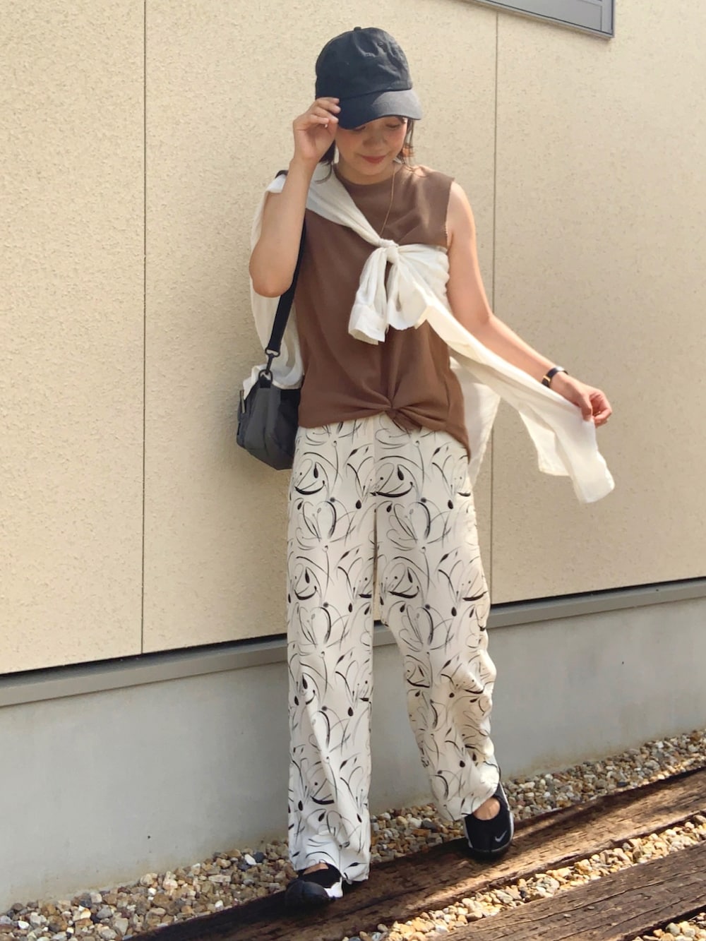 ホワイト系のその他パンツ、ベージュ系のタンクトップ、グレー系のボディバッグ/ウエストポーチを着用したレディースの夏コーディネートの2枚目の写真