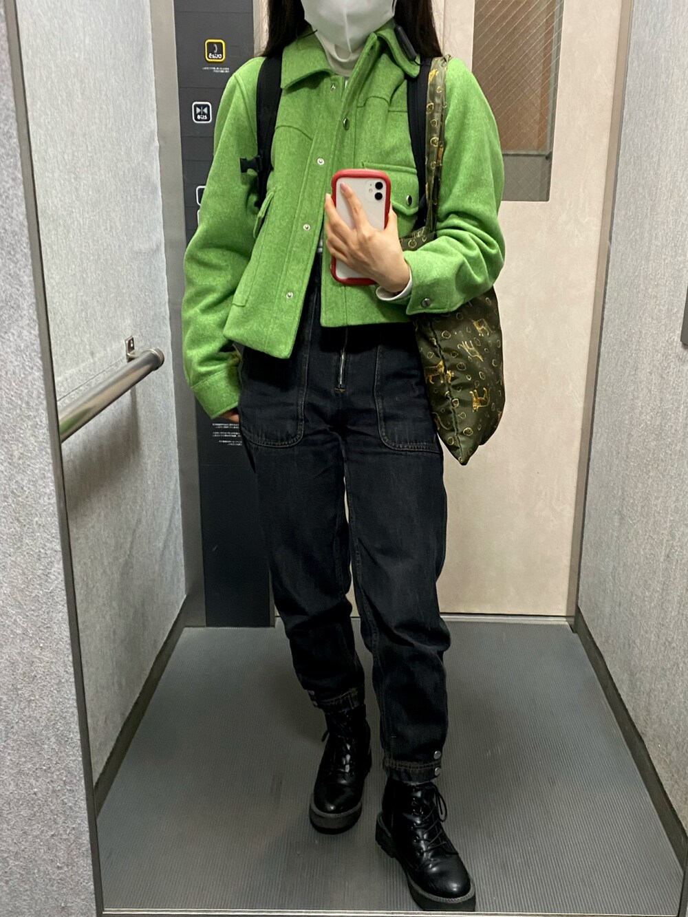 ブラック系のデニムパンツ、グリーン系のブルゾン、ホワイト系のTシャツ/カットソーを着用したレディースの秋コーディネートの2枚目の写真