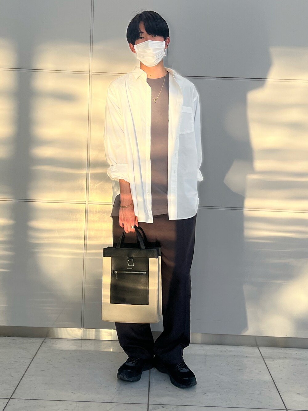 ホワイト系のシャツ/ブラウス、グレー系のTシャツ/カットソー、ベージュ系のトートバッグを着用したメンズの春コーディネートの2枚目の写真