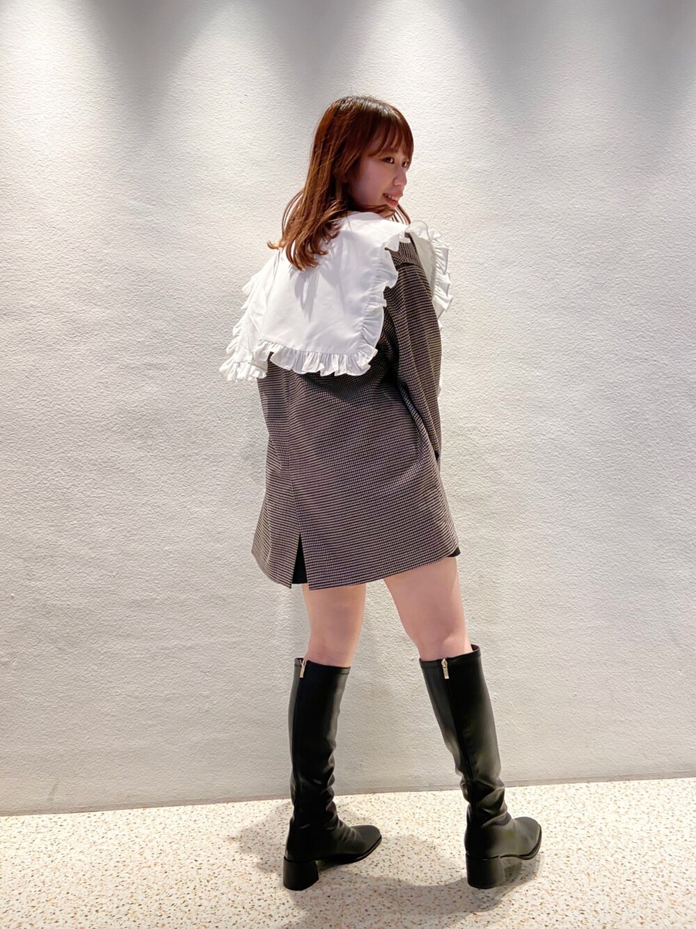 ブラウン系のテーラードジャケット、ベージュ系のニット/セーター、ブラック系のスカートを着用したレディースの夏コーディネートの2枚目の写真