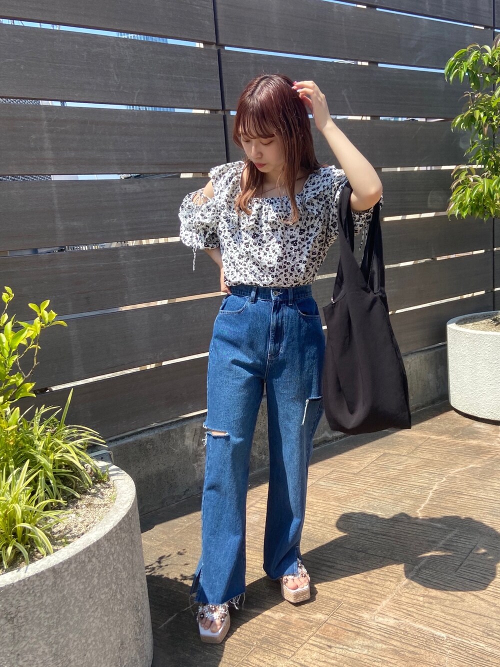 ホワイト系のシャツ/ブラウス、ブルー系のデニムパンツ、ブラック系のトートバッグを着用したレディースの春コーディネートの2枚目の写真