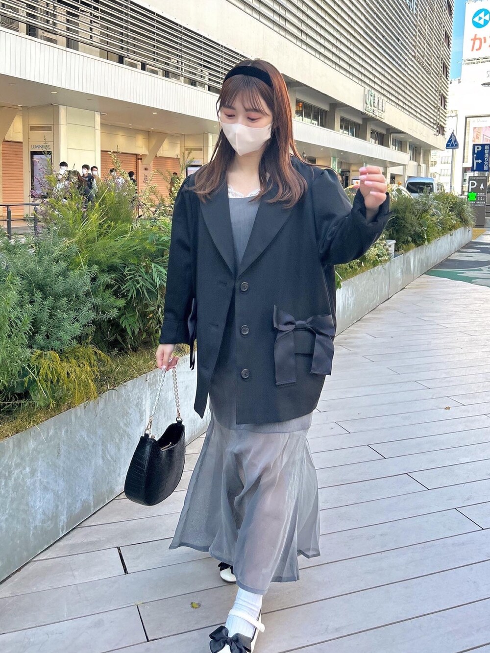 ブラック系のテーラードジャケット、グレー系のワンピース、ベージュ系のバレエシューズを着用したレディースの冬コーディネートの2枚目の写真