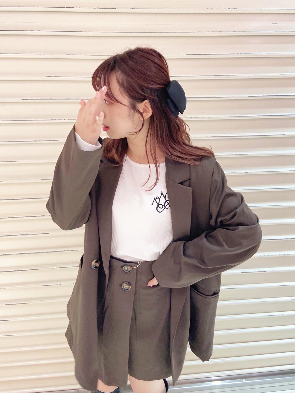 ブラウン系のテーラードジャケット、ホワイト系のTシャツ/カットソー、ブラウン系のその他パンツを着用したレディースの秋コーディネートの3枚目の写真