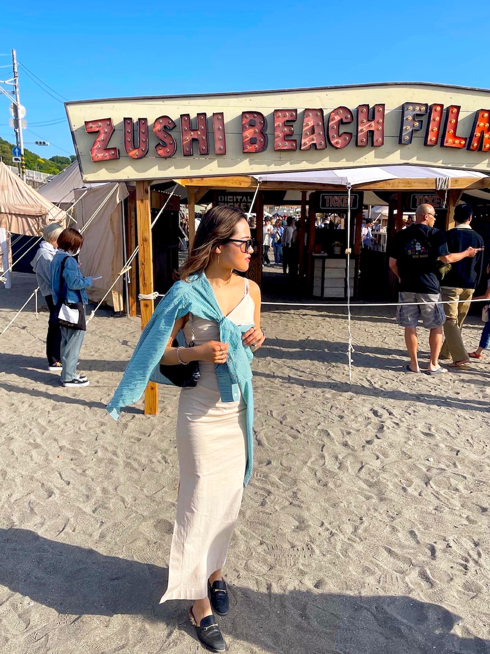 ベージュ系のワンピース、ブラック系のサングラスを着用したレディースの春コーディネートの5枚目の写真