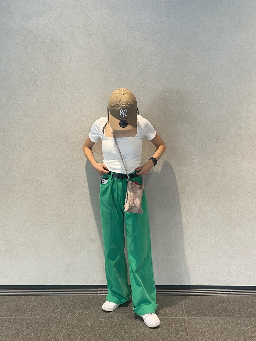 ホワイト系のスニーカー、ホワイト系のTシャツ/カットソー、ベージュ系のキャップを着用したレディースの春コーディネートの2枚目の写真