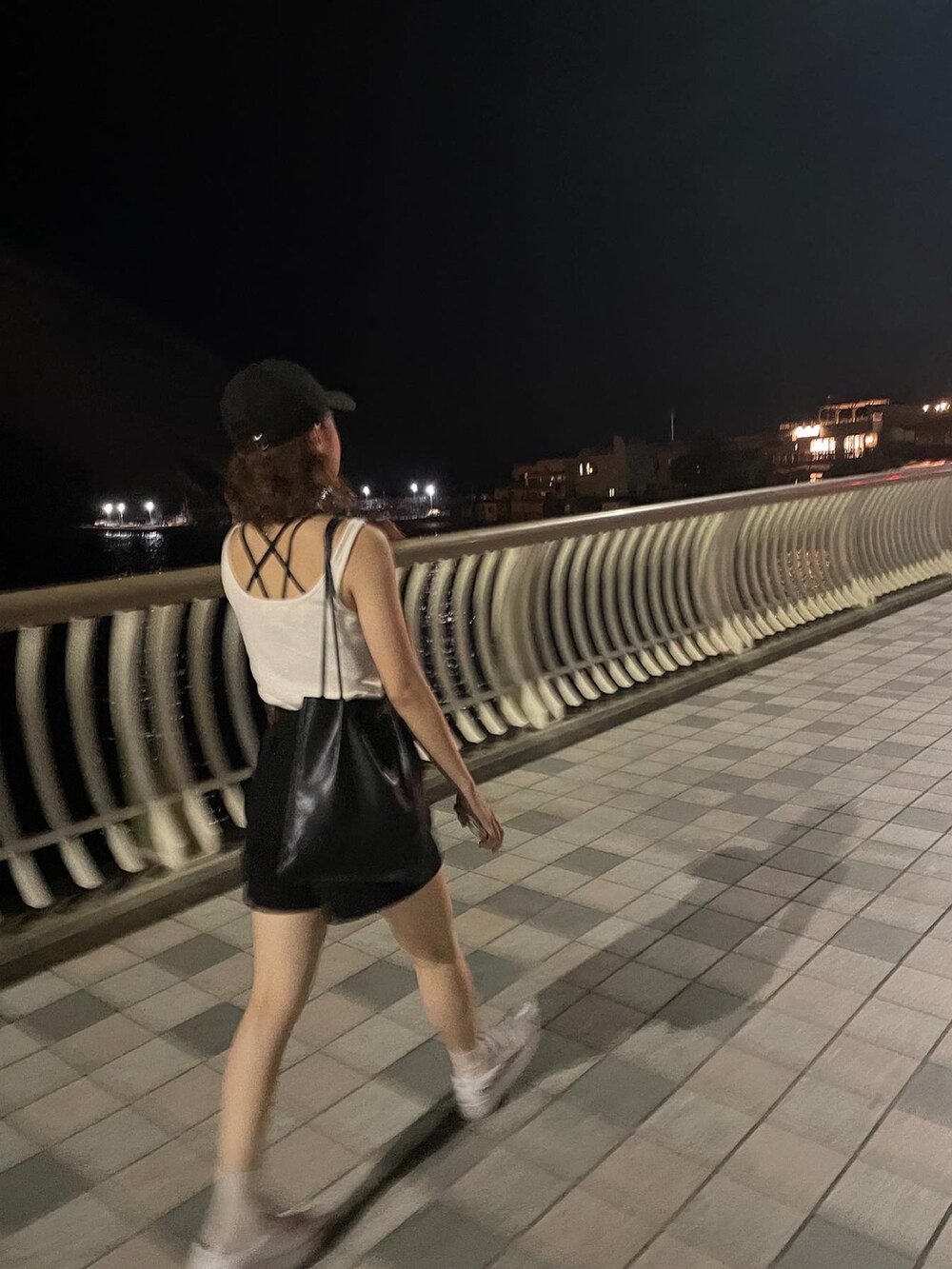 ホワイト系のタンクトップ、ブラック系のその他パンツ、ブラック系のキャップを着用したレディースの春コーディネートの3枚目の写真