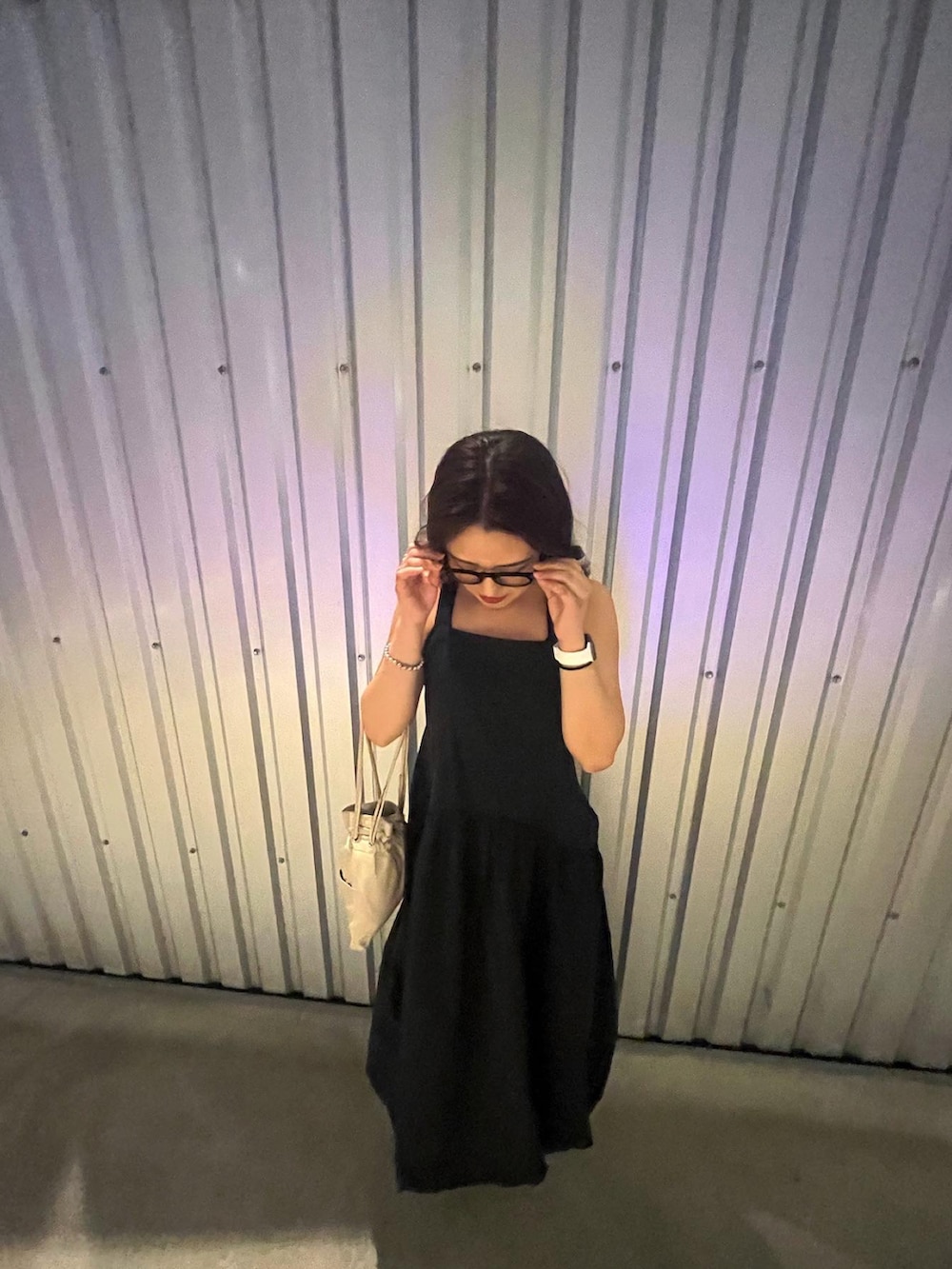 ベージュ系のショルダーバッグ、ブラック系のワンピース、ブラック系のメガネを着用したレディースの春コーディネートの3枚目の写真
