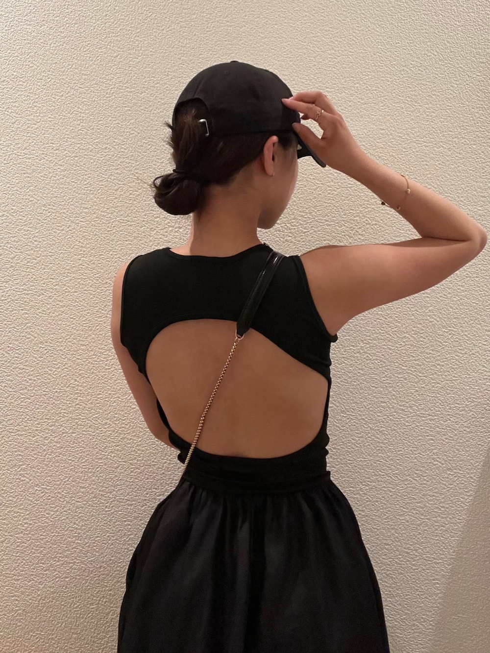 ブラック系のワンピース、ブラック系のキャップを着用したレディースの春コーディネートの3枚目の写真