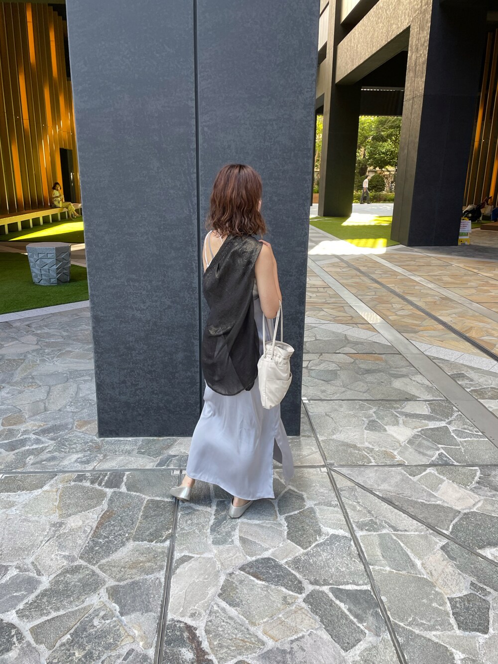 シルバー系のパンプス、ブラック系のシャツ/ブラウス、ホワイト系のトートバッグを着用したレディースの春コーディネートの3枚目の写真