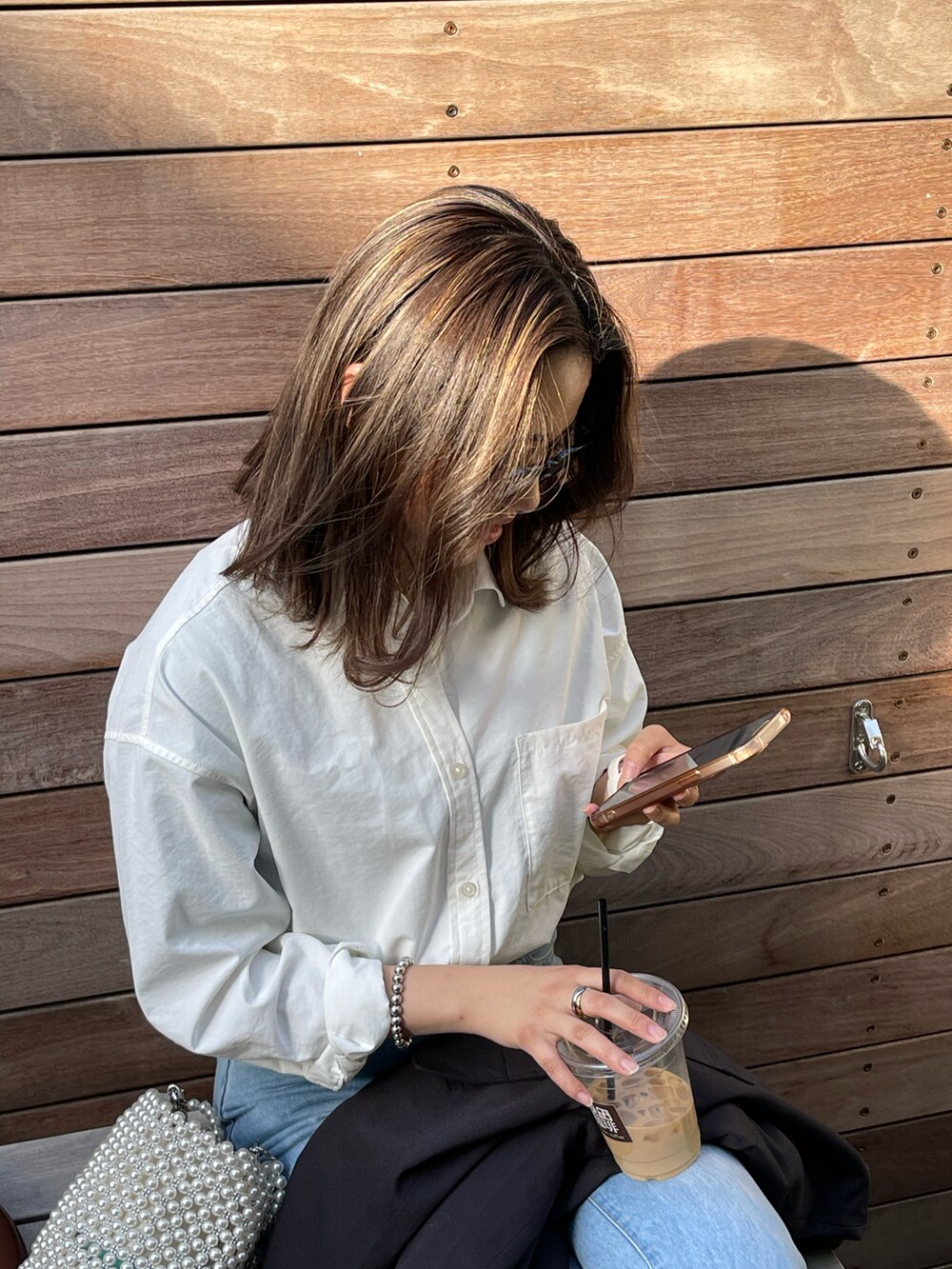 ホワイト系のシャツ/ブラウス、ブルー系のデニムパンツ、ブラック系のスニーカーを着用したレディースの春コーディネートの3枚目の写真