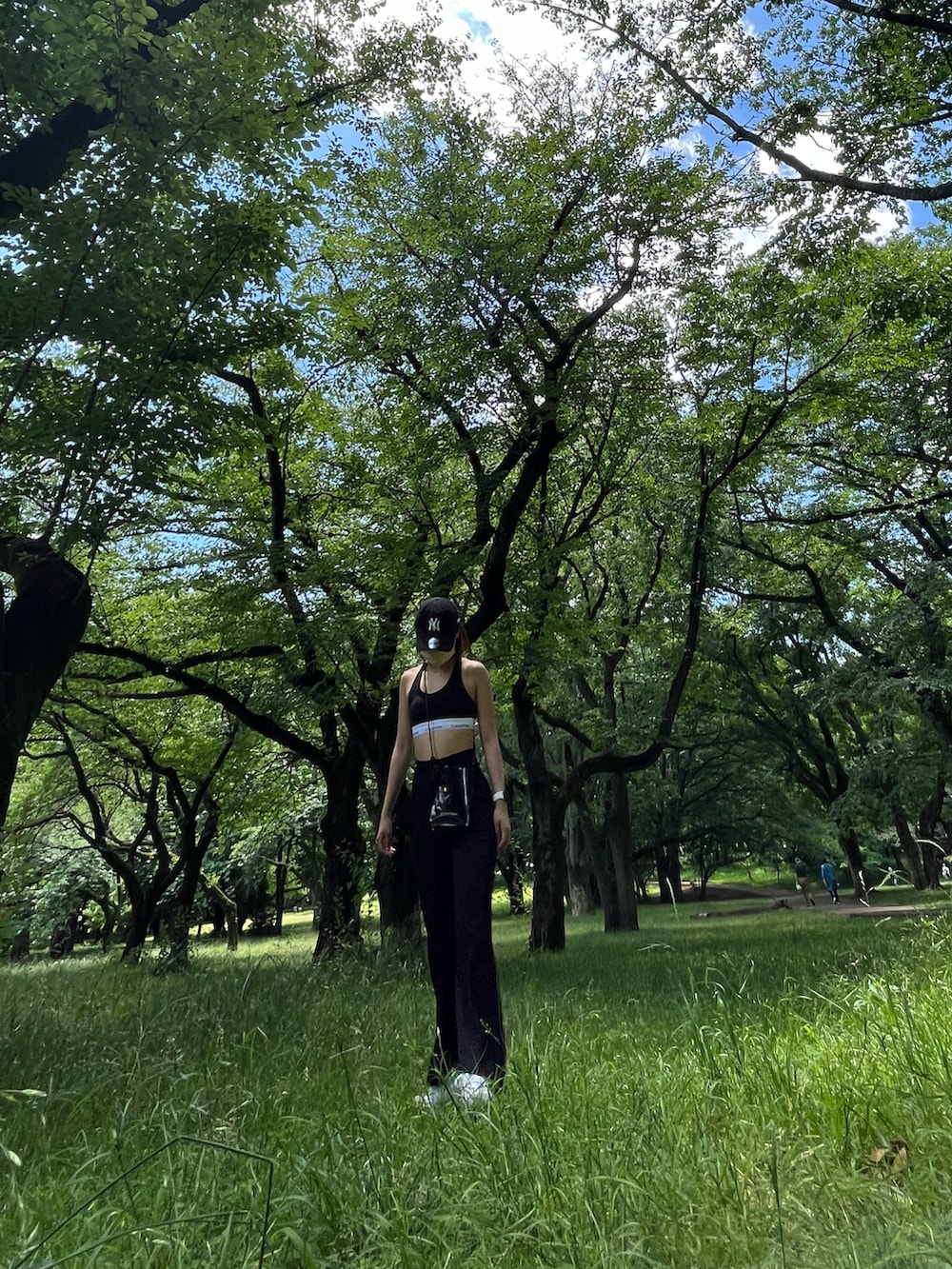 ブラック系のスラックス、ホワイト系のスニーカー、ブラック系のブラジャーを着用したレディースの春コーディネートの2枚目の写真