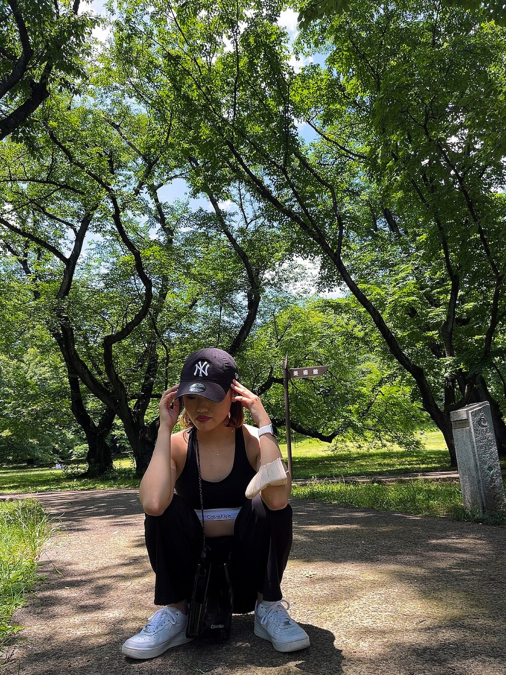 ブラック系のスラックス、ホワイト系のスニーカー、ブラック系のブラジャーを着用したレディースの春コーディネートの3枚目の写真