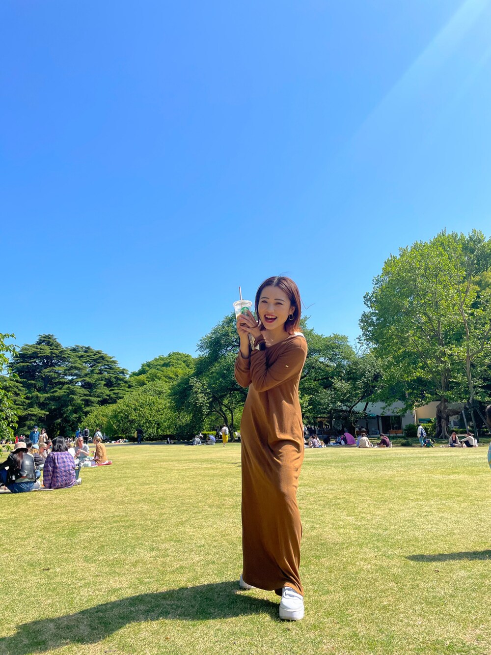 ホワイト系のショルダーバッグ、ブラウン系のスカートを着用したレディースの春コーディネートの3枚目の写真