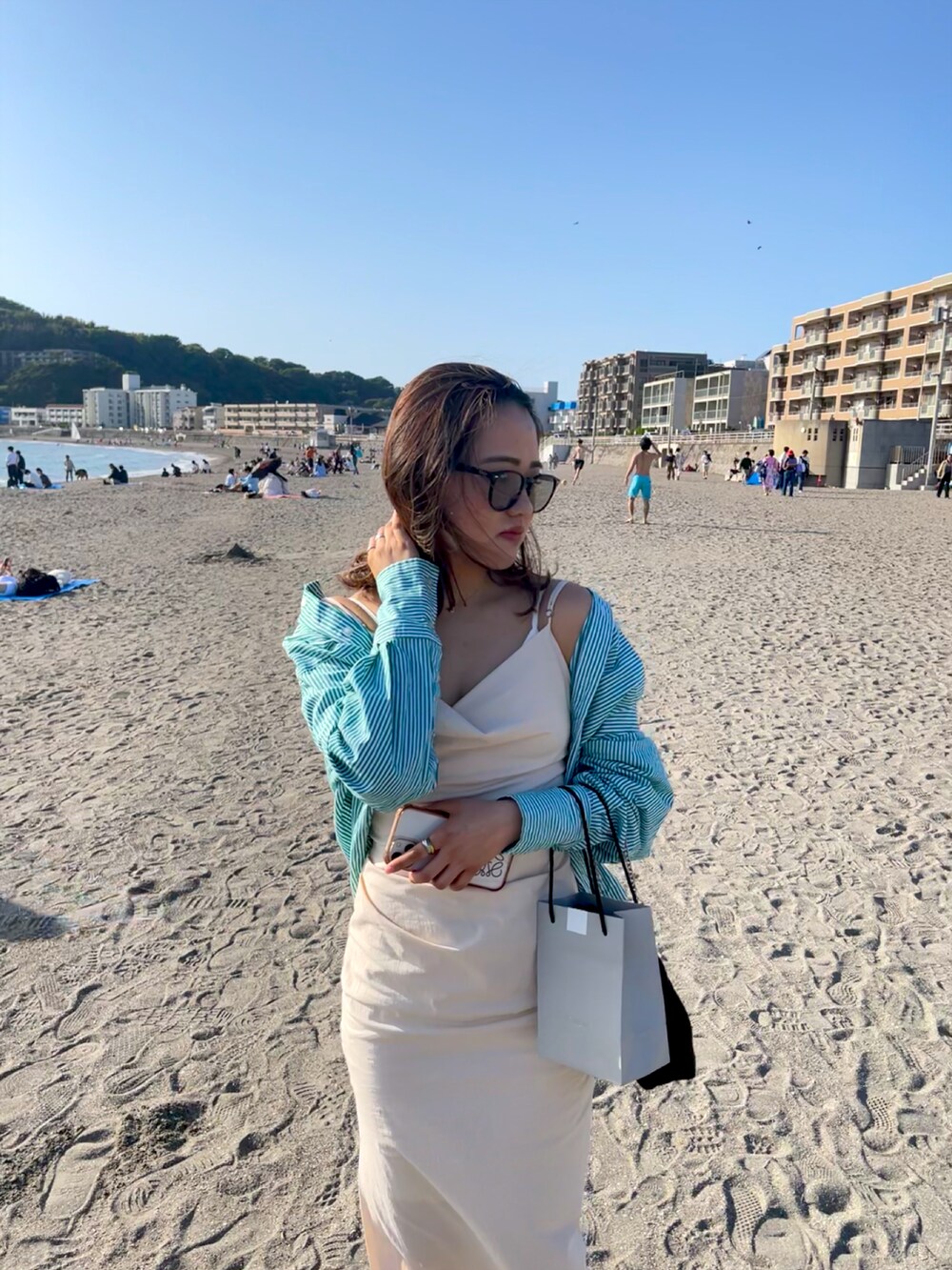 ベージュ系のワンピース、ブラック系のサングラスを着用したレディースの春コーディネートの2枚目の写真