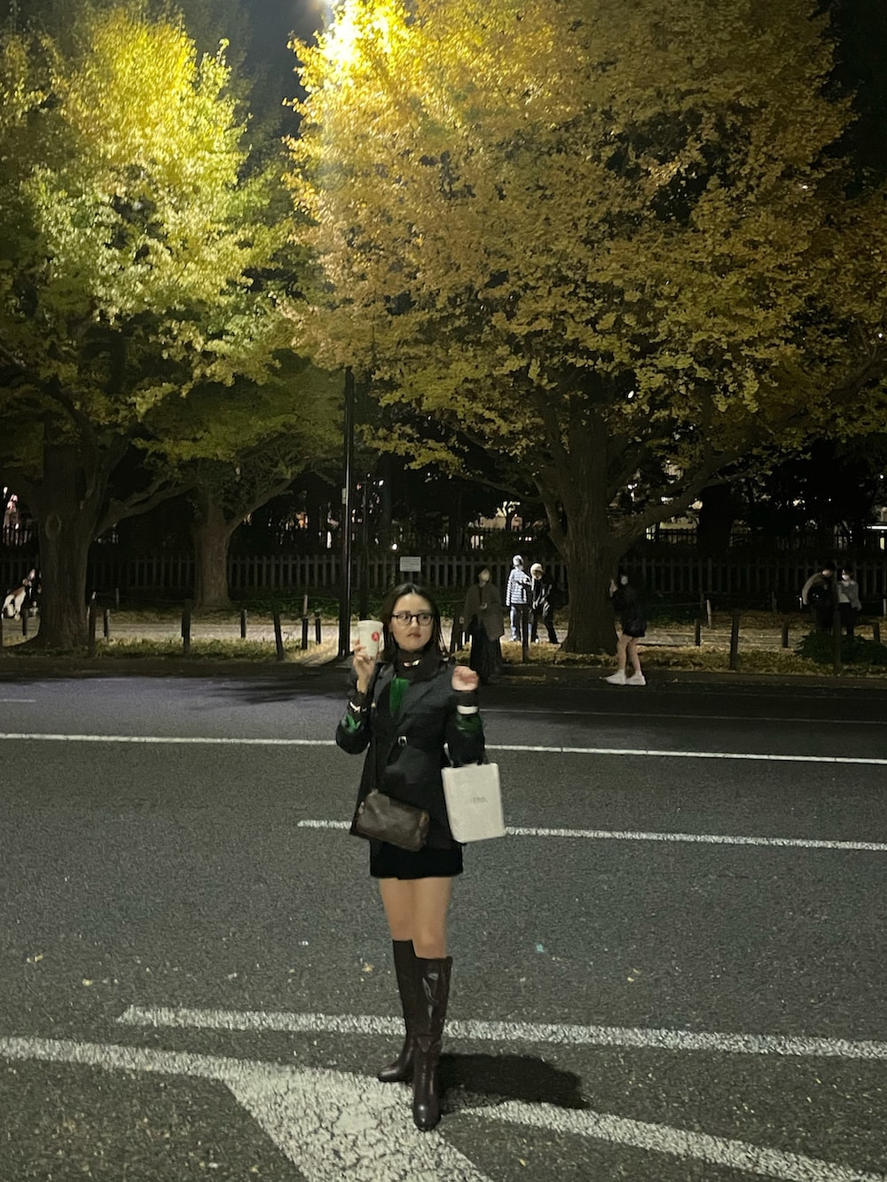 グリーン系のニット/セーター、ブラック系のパンツ、ブラウン系のブーツを着用したレディースの春コーディネートの3枚目の写真