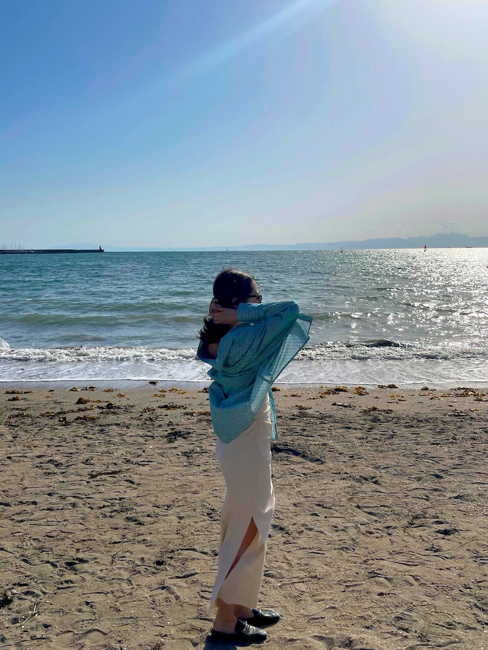 ベージュ系のワンピース、ブラック系のサングラスを着用したレディースの春コーディネートの4枚目の写真