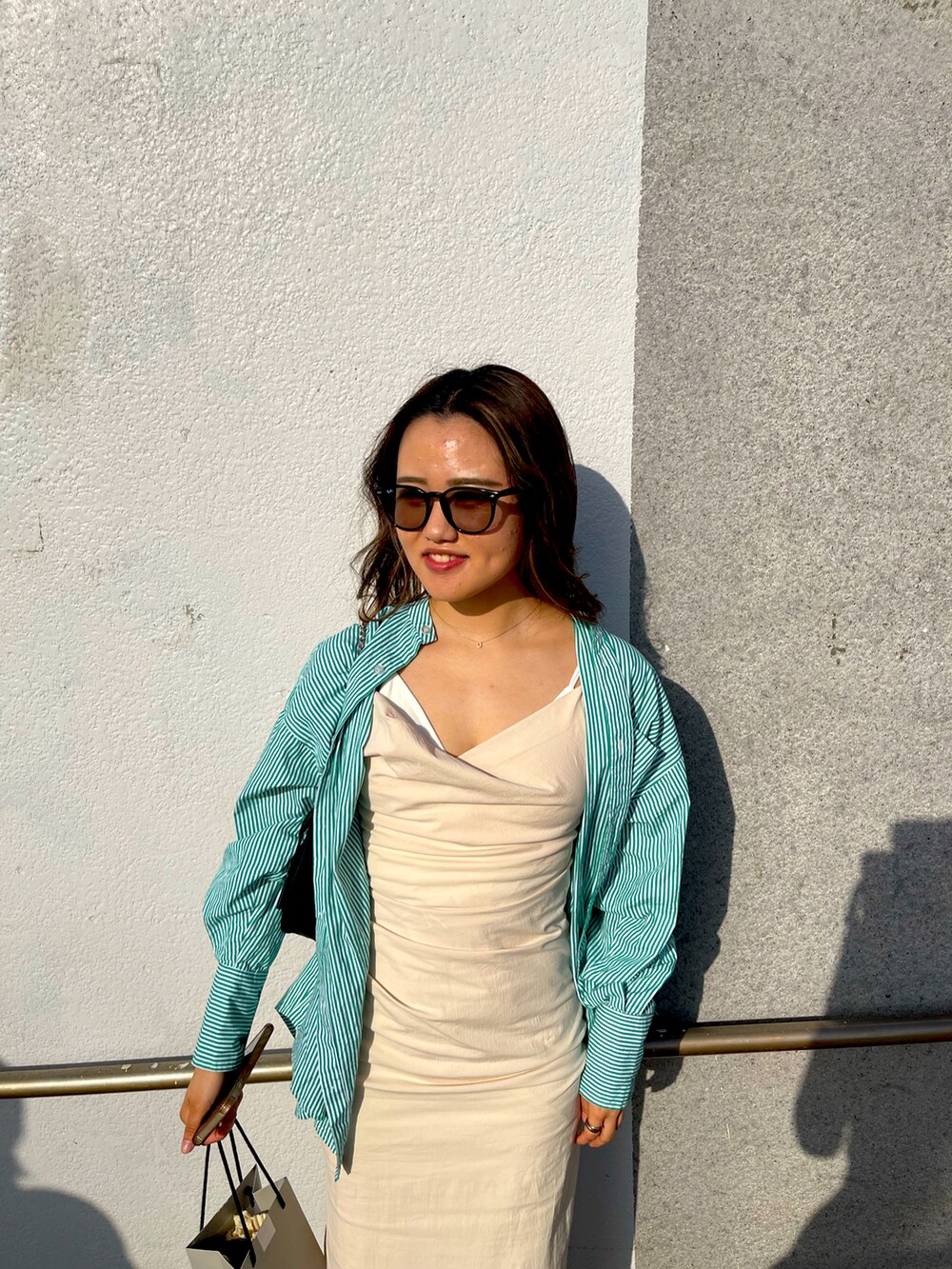 ベージュ系のワンピース、ブラック系のサングラスを着用したレディースの春コーディネートの3枚目の写真