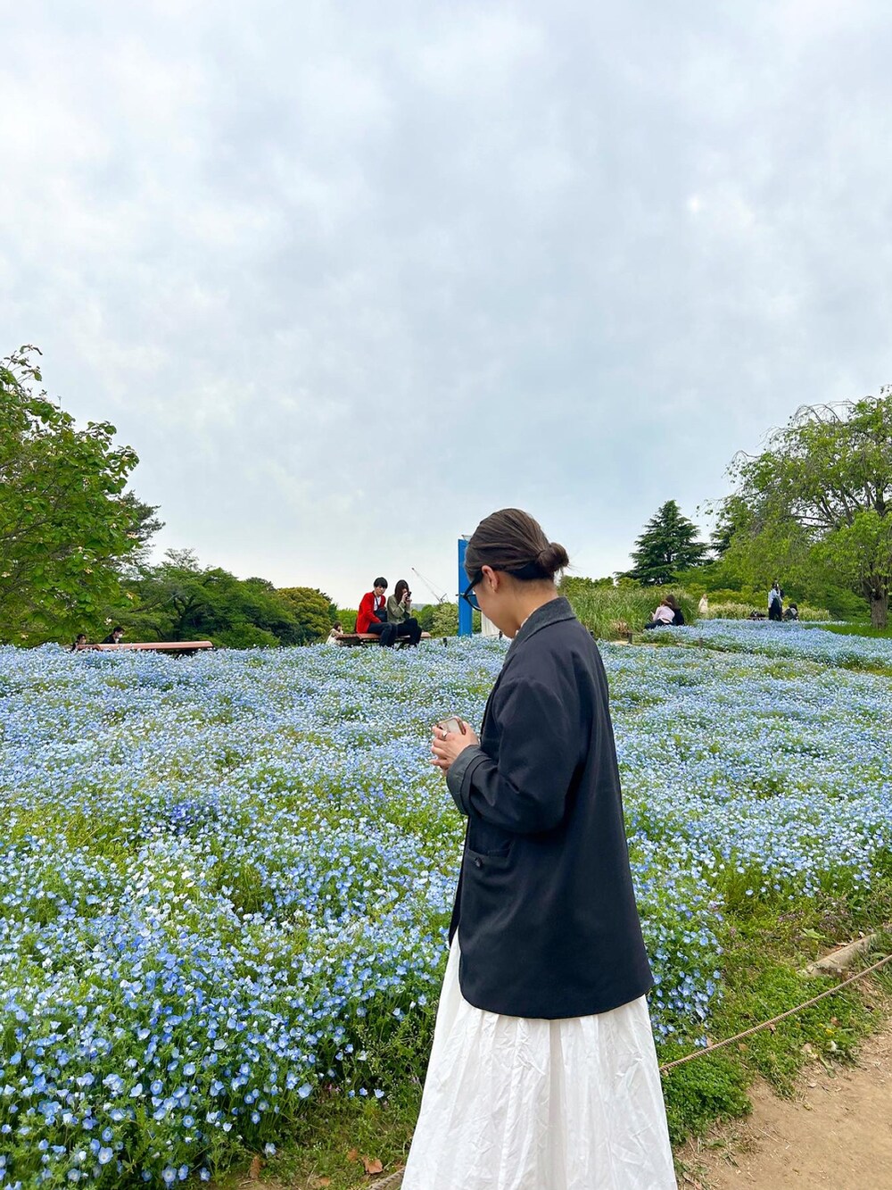 ホワイト系のワンピース、グレー系のジャケット/アウター、ブラック系のスニーカーを着用したレディースの春コーディネートの2枚目の写真