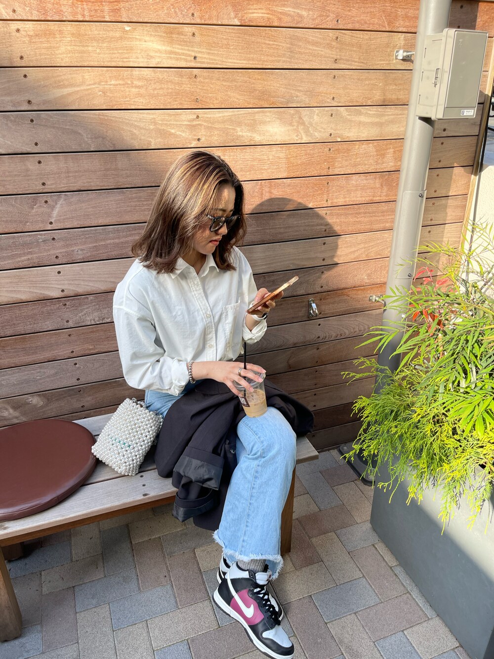 ホワイト系のシャツ/ブラウス、ブルー系のデニムパンツ、ブラック系のスニーカーを着用したレディースの春コーディネートの2枚目の写真