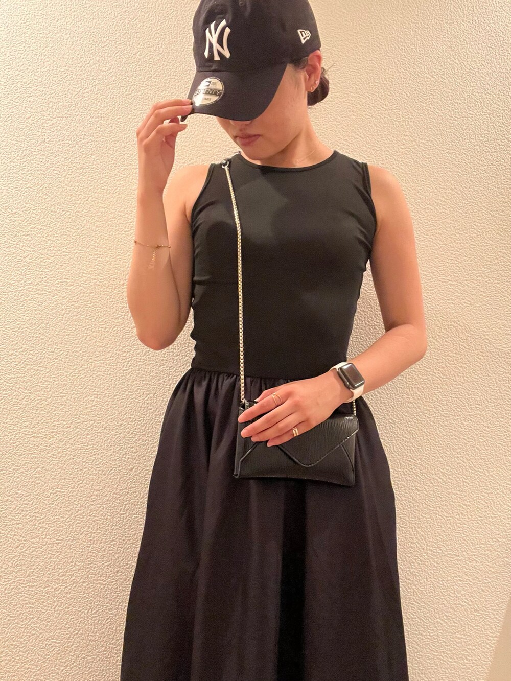 ブラック系のワンピース、ブラック系のキャップを着用したレディースの春コーディネートの2枚目の写真