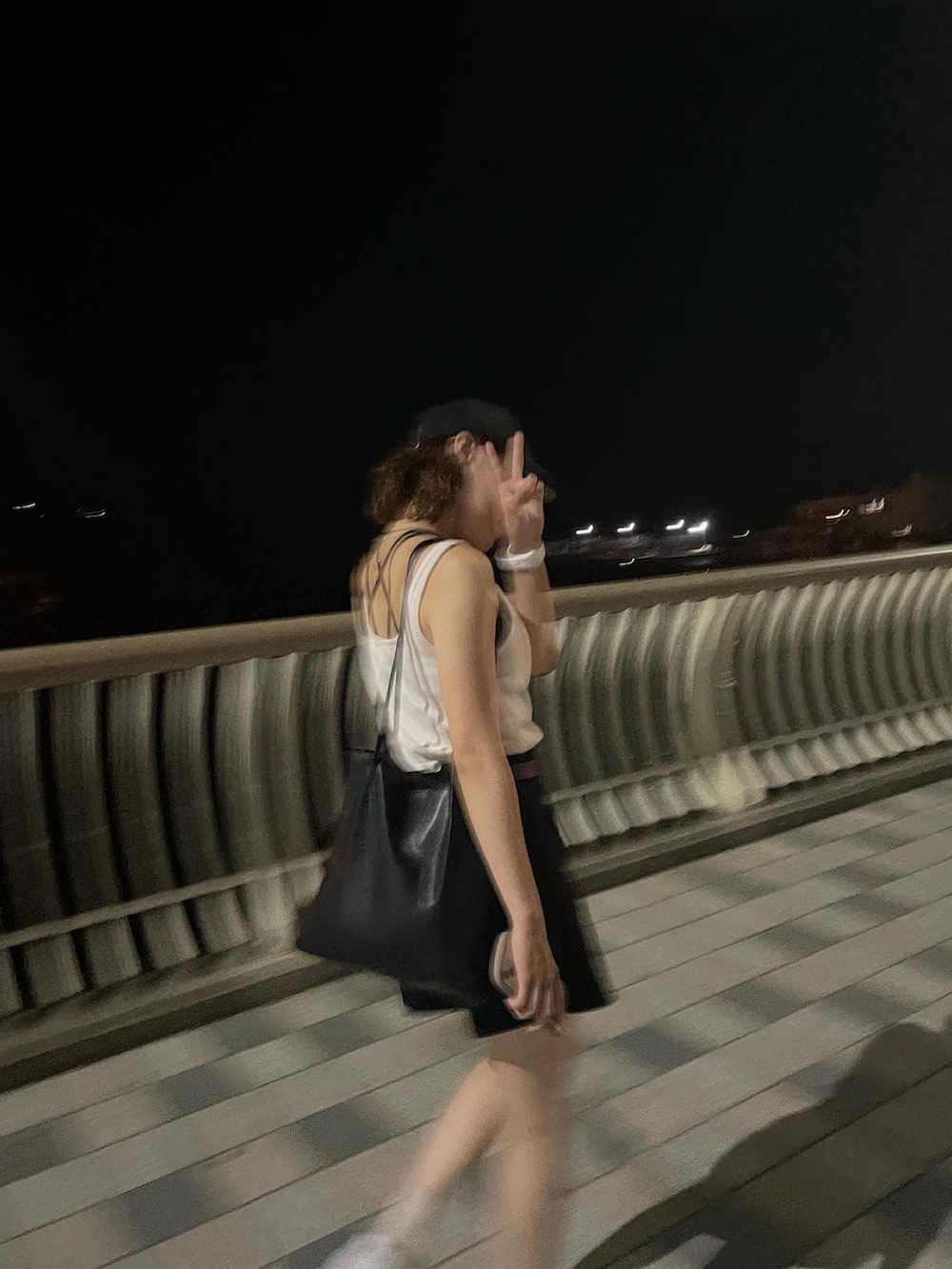 ホワイト系のタンクトップ、ブラック系のその他パンツ、ブラック系のキャップを着用したレディースの春コーディネートの2枚目の写真