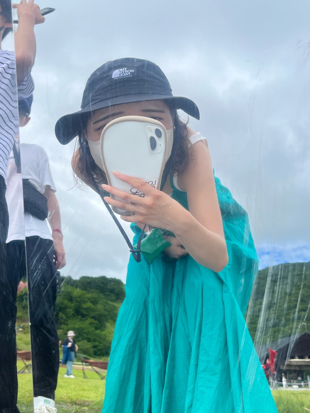 ブルー系のワンピース、ホワイト系のスニーカー、ブラック系のハットを着用したレディースの春コーディネートの4枚目の写真