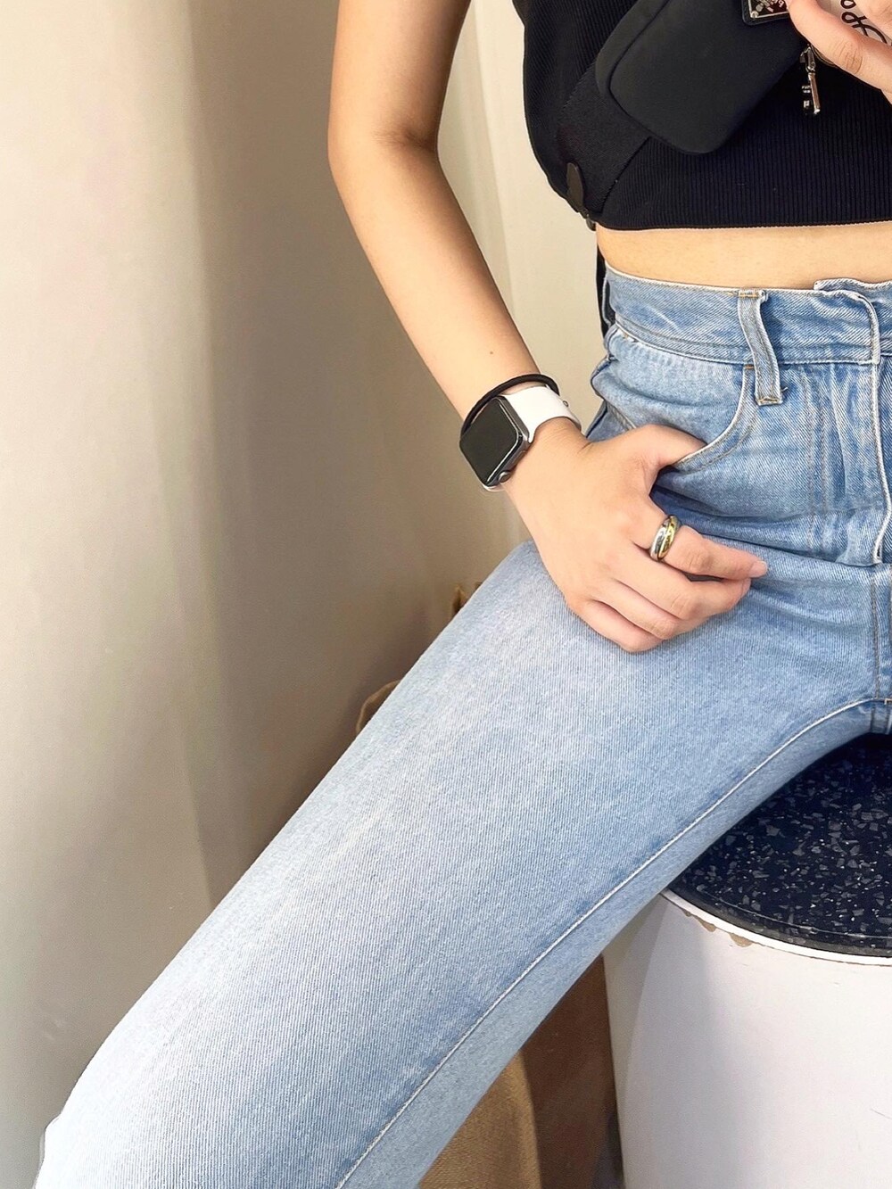 ブラック系のタンクトップ、ブルー系のデニムパンツ、ブラック系のバッグを着用したレディースの春コーディネートの3枚目の写真