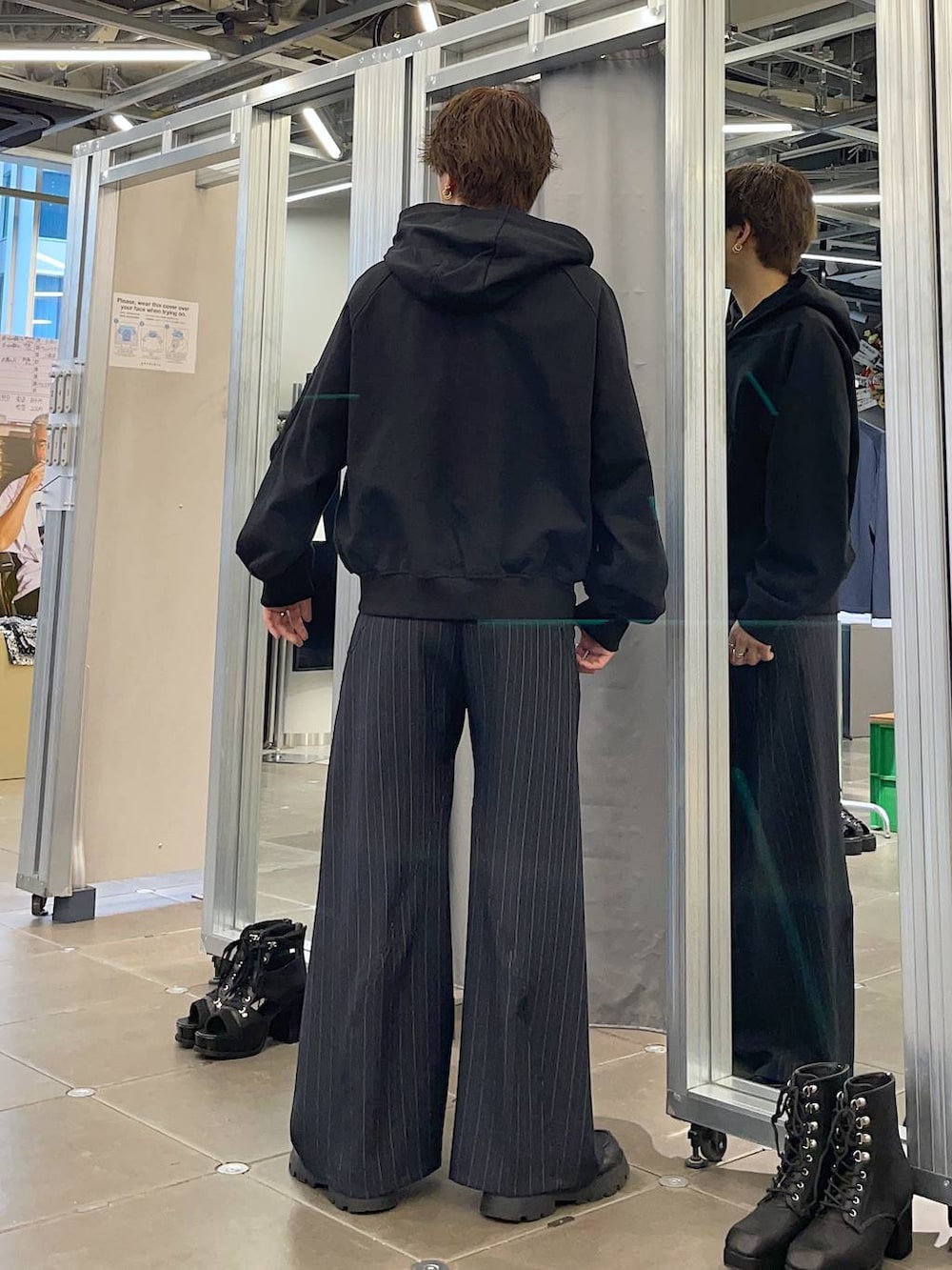 ブラック系のドレスシューズ、ブルー系のスラックス、ブラック系のパーカーを着用したメンズの春コーディネートの2枚目の写真