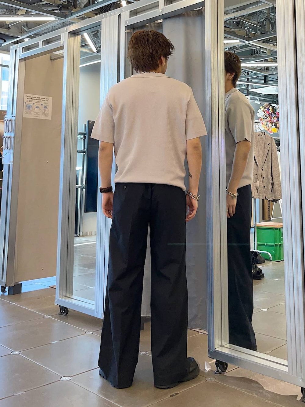 ブラック系のドレスシューズ、ブラック系のスラックス、グレー系のポロシャツを着用したメンズの春コーディネートの2枚目の写真