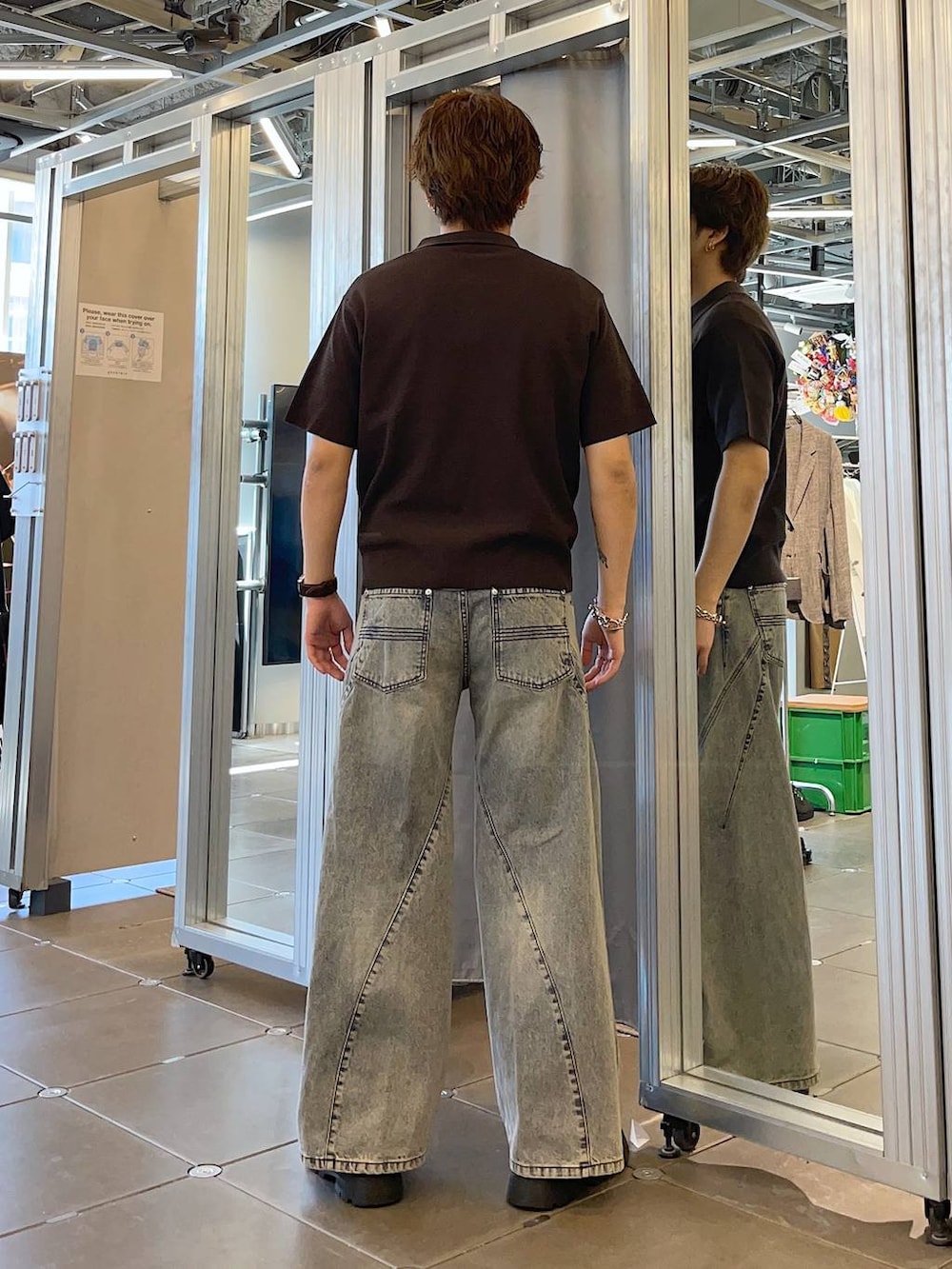 ブラック系のドレスシューズ、ブルー系のデニムパンツ、ブラウン系のポロシャツを着用したメンズの春コーディネートの2枚目の写真
